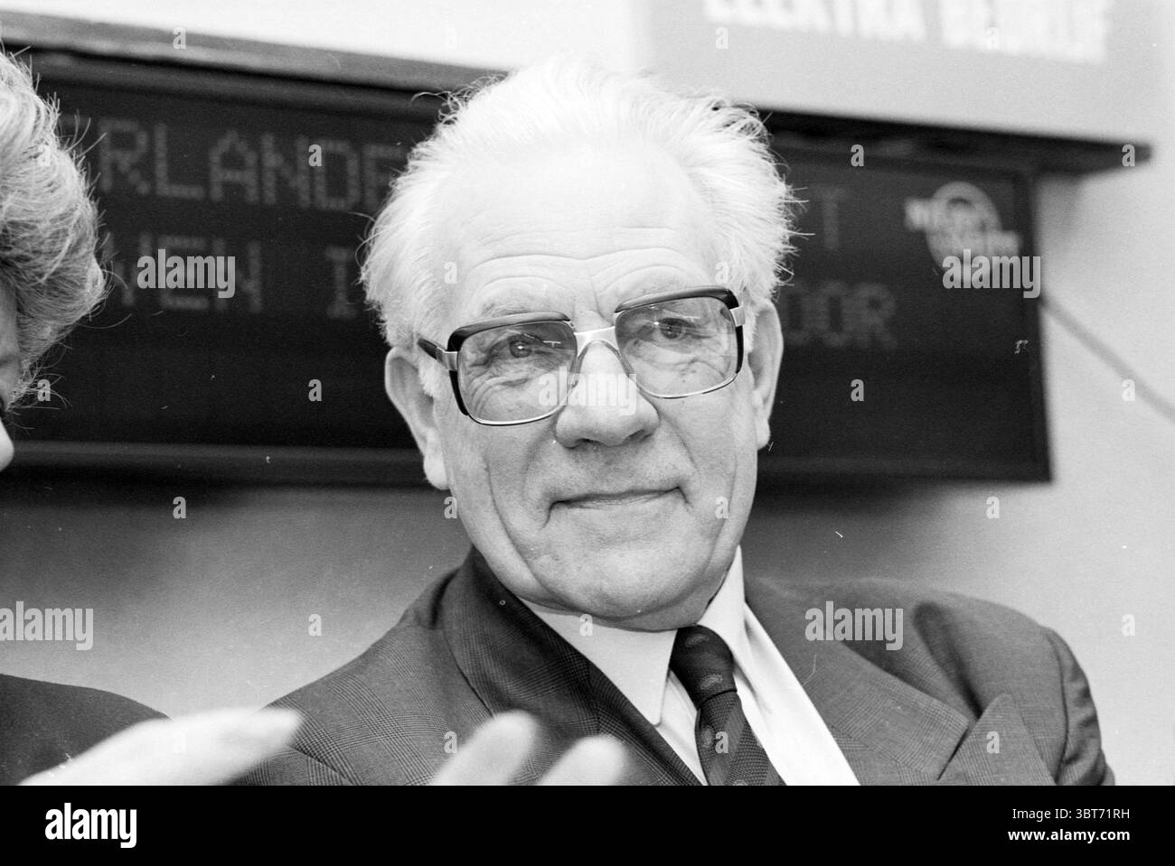 Ritratto del Sig. Jansen direttore di IJmuiden Seaport Transfer Fisheries e altri pescivendoli pesca IJmuiden Paesi Bassi, Whizgle News, Dutch Desk, Paesi Bassi, 1950 - 2000 il 09-04-1989. L'immagine mostra questi argomenti. Nella scena, c'è un signore più anziano con una presenza distinta, che trasuda un senso di saggezza ed esperienza. Ha una testa di capelli argentati, la parte posteriore pettinata e indossa occhiali grandi ed eleganti che accentuano il suo sguardo premuroso. Le sue caratteristiche facciali sono caratterizzate da un sorriso caldo, che rivela leggere rughe, che si aggiungono al suo carisma. L'uomo è vestito in una forma Foto Stock