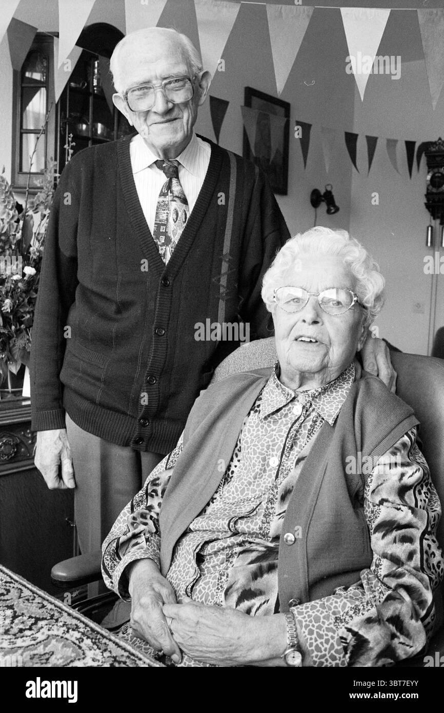 Sposato da 60 anni Willemsen Haarlem Paesi Bassi, Whizgle News, Dutch Desk, Paesi Bassi, 1950 - 2000 il 03-04-1997. L'immagine include questi argomenti. In un ambiente accogliente, due persone anziane sono all'avanguardia nella scena. L'uomo sta dietro una donna seduta su una sedia, trasuda un senso di calore e di connessione familiare. L'uomo ha uno stile classico, con un cardigan scuro sopra una camicia button-up, con motivo diagonale. Indossa occhiali appollaiati sul naso, e la sua espressione irradia dolcezza e saggezza, evidenziata dalle pieghe sul viso e da una S. Foto Stock