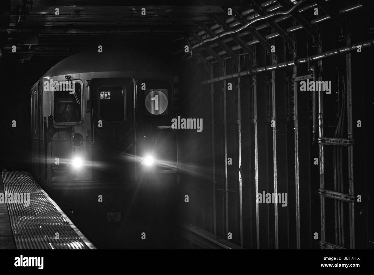 Immagine monocromatica della metropolitana MTA numero 1 di New York City che entra nella stazione della metropolitana di Times Square, Lower Manhattan, New York, Stati Uniti. Foto Stock