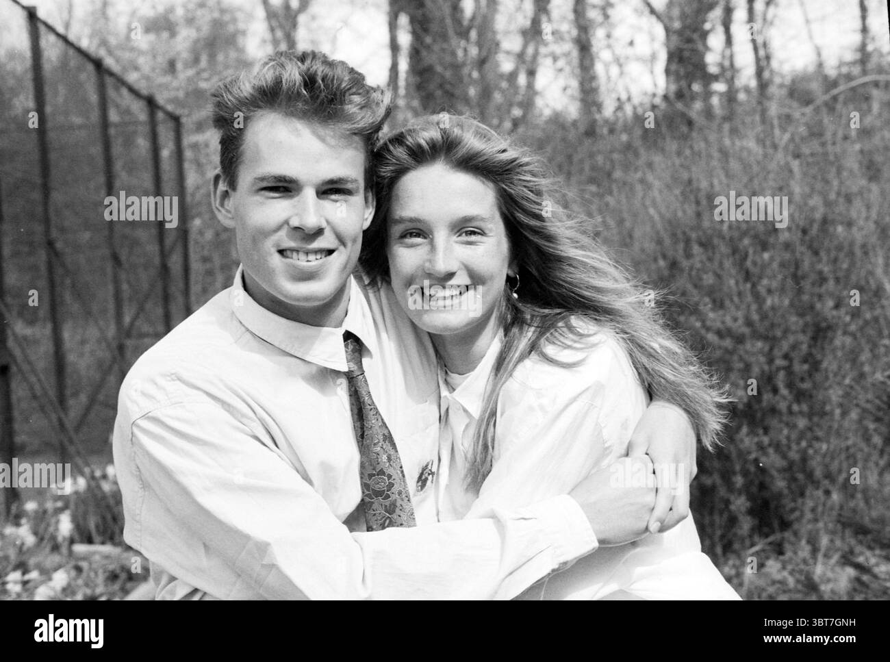 2 partecipanti concorso di modellazione Santpoort Models Santpoort, Whizgle News, Dutch Desk, Paesi Bassi, 1950 - 2000 il 17-04-1990. Questi sono gli elementi dell'immagine. In un ambiente tranquillo all'aperto, due giovani adulti siedono a stretto contatto, irradiando calore e gioia. Lo sfondo presenta una lussureggiante varietà di vegetazione, con un pizzico di fiori in fiore che aggiungono un tocco di colore alla scena. Gli alberi torreggianti si allungano verso l'alto, i loro rami formano una cornice organica intorno alla coppia, mentre la luce solare soffusa filtra attraverso le foglie, creando un delicato effetto smorzato sul terreno. Il giovane, che trasuda confidenza Foto Stock