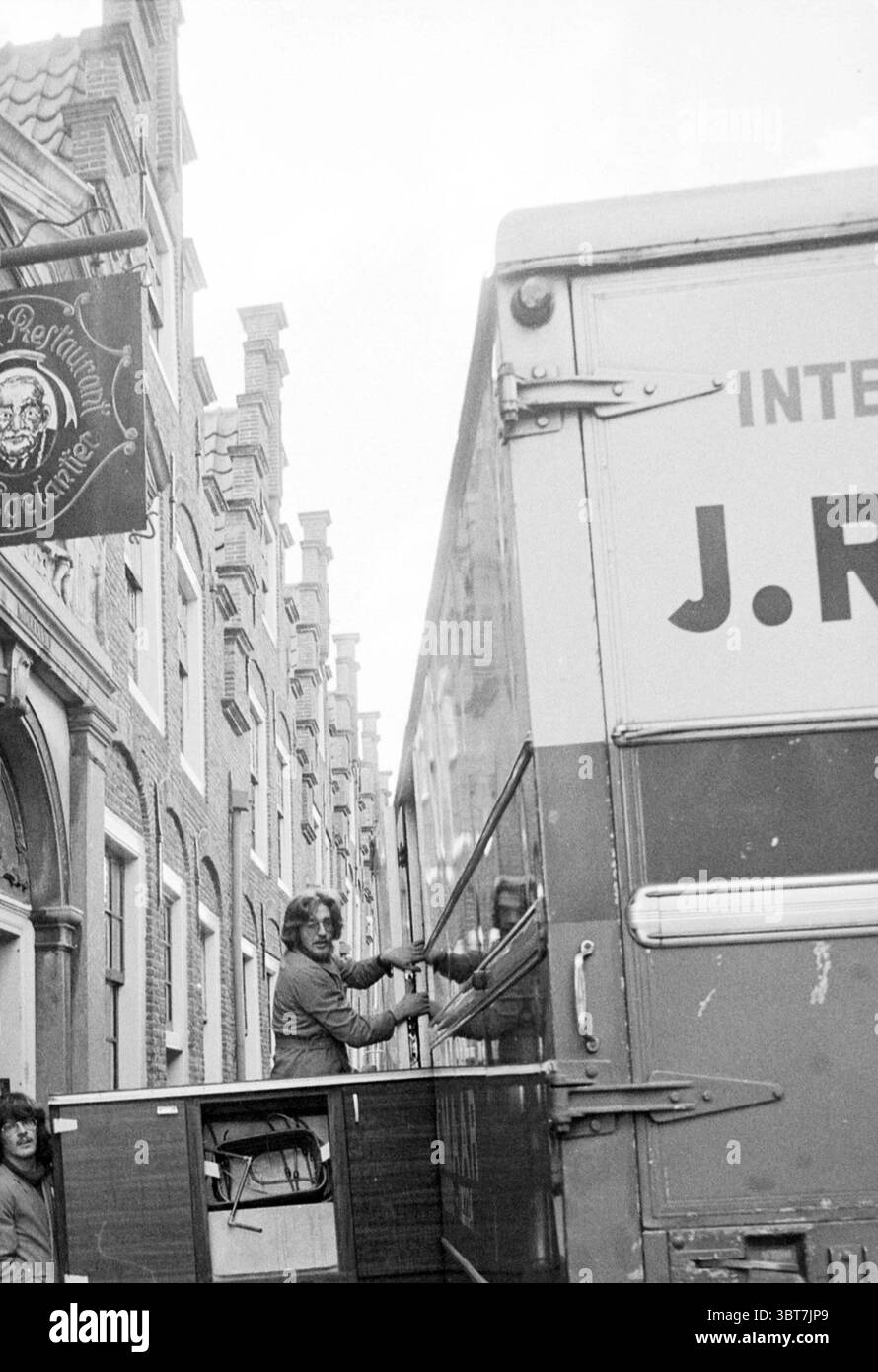 Clearing café Cultural Centre De Egelantier (furgone mobile per strada) Haarlem Groot Heiligland Paesi Bassi, Whizgle News, Dutch Desk, Paesi Bassi, 1950 - 2000 il 20-11-1978. L'immagine include questi argomenti. In una vivace scena urbana, una strada stretta presenta un mix di edifici storici con un'architettura distintiva. Le facciate mostrano una combinazione di mattoni e pietra, con alte finestre strette e dettagli ornamentali. Da un lato, c'è un cartello sopra, che suggerisce un locale vicino, possibilmente un pub o un ristorante, aggiungendo un tocco di carattere all'ambiente. In prima linea, una grande Foto Stock