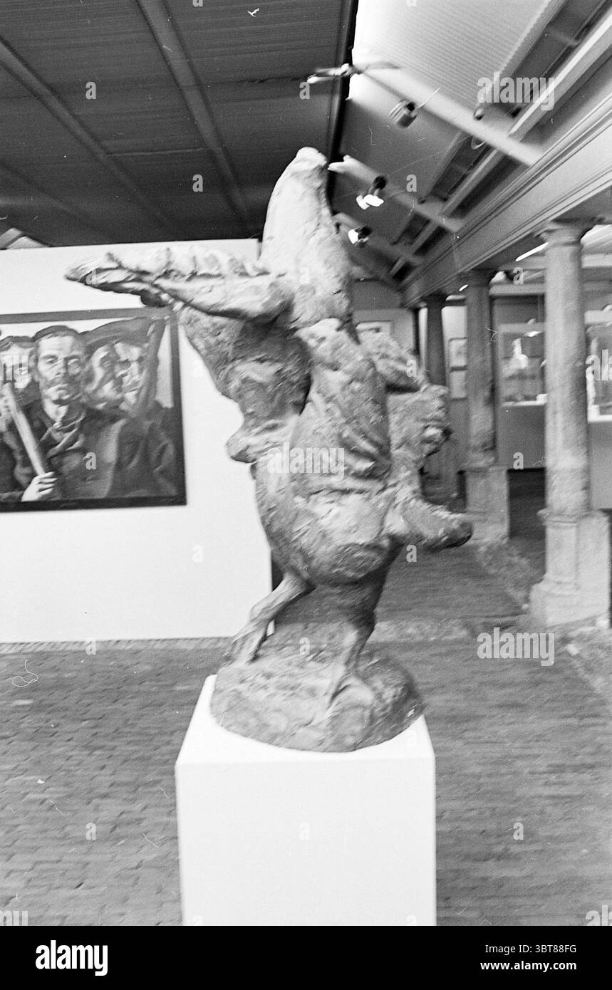 Esposizione Agricoltura mostre, Whizgle News, Dutch Desk, Paesi Bassi, 1950 - 2000 il 04-06-1965. Questi sono gli argomenti nell'immagine. La scena raffigura una galleria d'arte con un'impressionante scultura tridimensionale come punto focale. La scultura presenta una forma dinamica, che suggerisce movimento, con caratteristiche esagerate che evocano un senso di dramma ed emozione. La figura sembra essere in un gesto verso l'alto, forse imitando il volo o un momento di festa. Intorno alla scultura, le pareti della galleria sono adornate da varie opere d'arte, tra cui dipinti che aggiungono profondità e carattere alla scultura Foto Stock