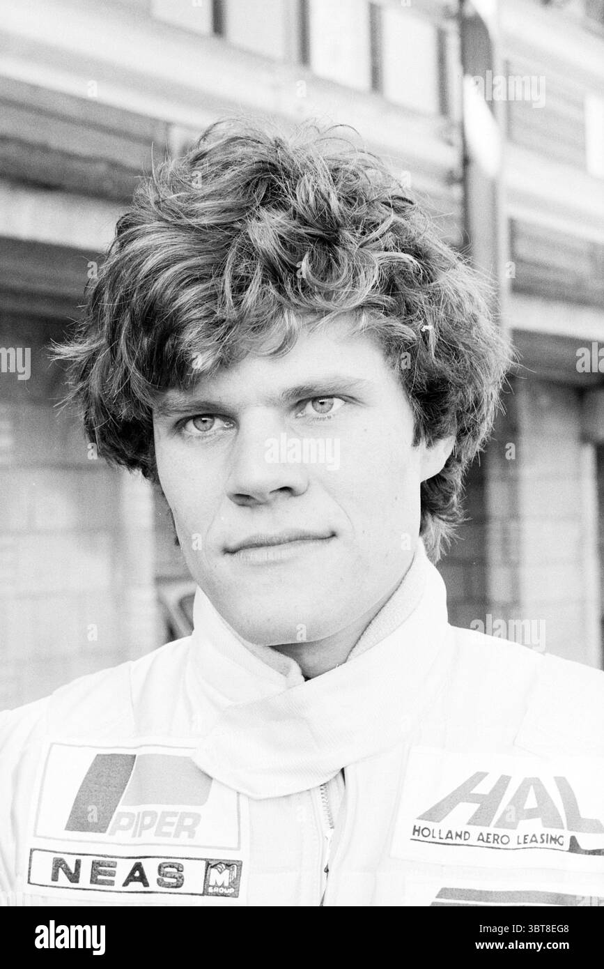 Apertura curva Marlboro circuito Zandvoort Zandvoort apertura aperture messo in uso Zandvoort, Whizgle News, Dutch Desk, Paesi Bassi, 1950 - 2000 on 26-03-1980. Questi sono gli elementi dell'immagine. La scena presenta un giovane uomo con una testa distintamente voluminosa di capelli ricci, che gli conferisce un aspetto un po' giocoso ma determinato. La sua espressione è seria, con occhi profondi e focalizzati che suggeriscono un senso di concentrazione o di prontezza. È vestito con una tuta da corsa di colore chiaro, con patch o loghi che indicano i legami di sponsorizzazione, probabilmente associati all'industria automobilistica Foto Stock