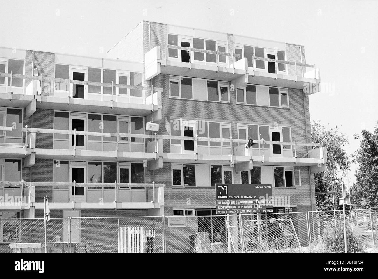 Nuova costruzione angolo Spaarndamseweg Jan Gijzenkade Haarlem Spaarndamseweg Paesi Bassi, Whizgle News, Dutch Desk, Paesi Bassi, 1950 - 2000 il 11-07-1990. Questi argomenti vengono visualizzati nell'immagine. La scena cattura un edificio a tre piani caratterizzato da un design architettonico moderno. L'esterno presenta una combinazione di mattoni chiari e scuri, creando un aspetto strutturato ed equilibrato. Ogni piano vanta una serie di balconi racchiusi da ringhiere trasparenti, che danno un senso di apertura e consentono il relax all'aperto. Diverse finestre sulla facciata sono aperte o parzialmente conc Foto Stock
