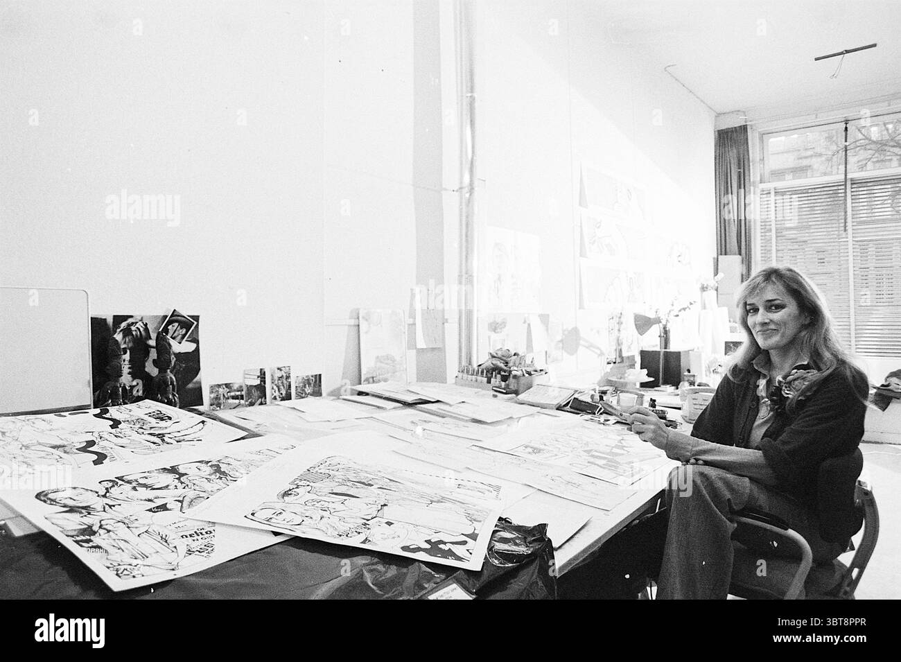 Marte Röling: Graphic Designer Persons, Whizgle News, Dutch Desk, Paesi Bassi, 1950 - 2000 il 21-01-1975. Questi argomenti vengono visualizzati nell'immagine. La scena raffigura uno spazio di lavoro pieno di creatività e arte. Una donna siede su un grande tavolo traboccante di varie illustrazioni, ognuna con disegni intricati e schizzi di personaggi. Ha un comportamento calmo, con un sorriso dolce che suggerisce una passione per il suo mestiere. La tavola stessa è ordinata ma organizzata, con fogli di carta che mostrano lavori completati e non finiti. Alcune illustrazioni sono in colori vivaci, mentre altre sono monocromatiche Foto Stock