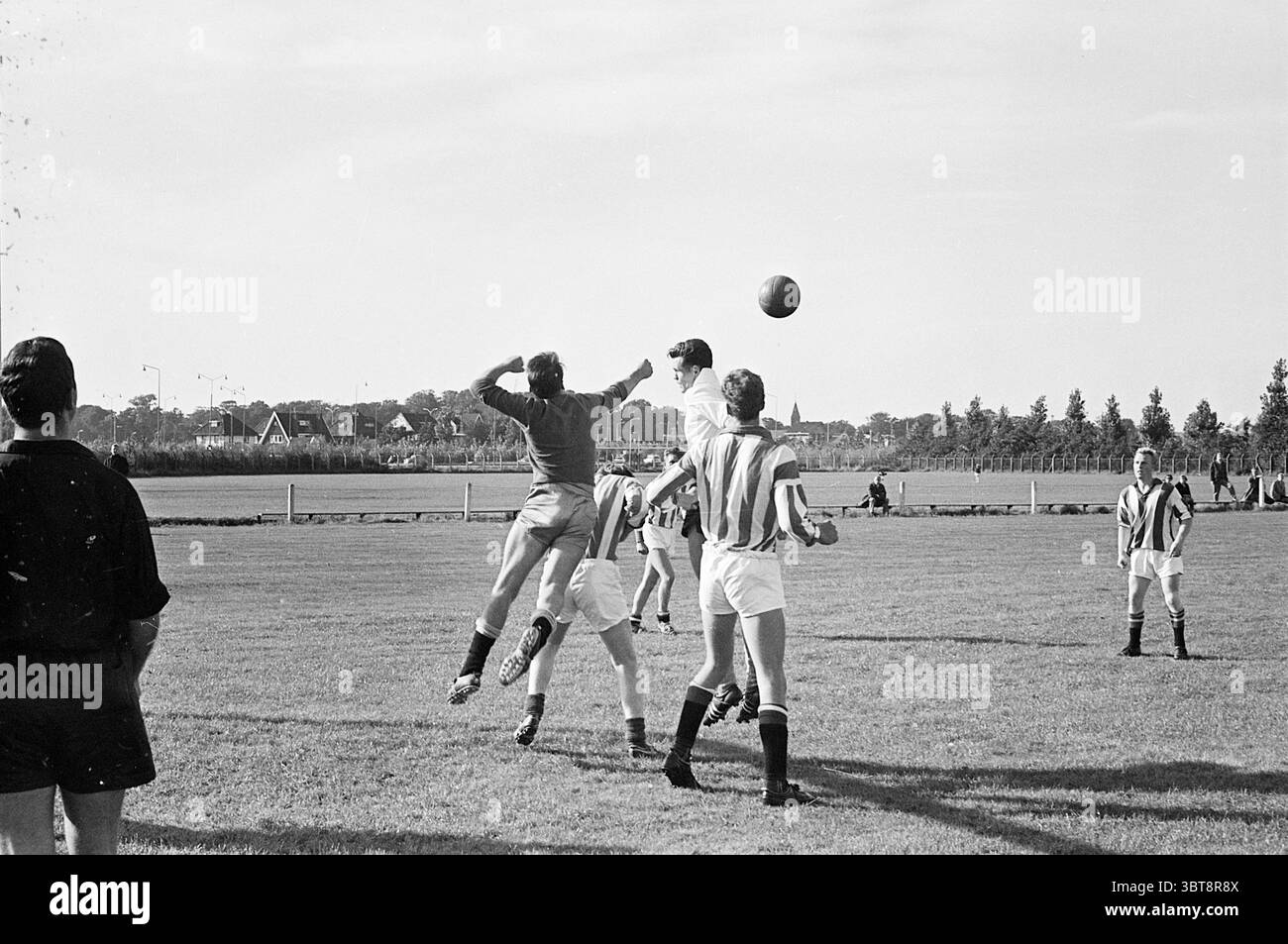 Renova - Waterloo football people Van Schleswijk Haarlem Arie den Ouden Haarlem Steur Haarlem Football, Whizgle News, Dutch Desk, Paesi Bassi, 1950 - 2000 il 13-09-1964. L'immagine contiene questi argomenti. In un vivace ambiente esterno, una vivace partita di calcio si svolge su un campo illuminato dal sole circondato da una vegetazione lussureggiante. La scena è piena di giocatori rivestiti in divise distinte: Alcuni vestiti con strisce verticali, altri con colori solidi. Il cielo è blu brillante, con alcune morbide nuvole bianche che si spostano sopra la testa, gettando ombre delicate sull'erba. L'attenzione è concentrata su un momento d'azione come un unico gioco Foto Stock