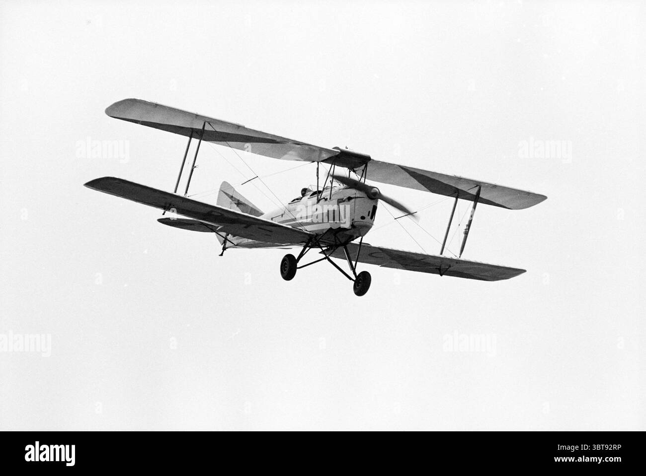Inaugurazione di expo Schiphol 60 anni + aereo 'Tiger Moth' + Principe Bernhard' ricevimenti reali e visite reali Schiphol Schiphol, Whizgle News, Dutch Desk, Paesi Bassi, 1950 - 2000 il 16-05-1980. L'immagine contiene questi argomenti. La scena raffigura un aereo che vola attraverso un cielo esteso. L'aereo ha un design biplano, caratterizzato da due serie di ali, elegantemente strutturate e posizionate orizzontalmente. Il corpo del velivolo è dipinto in una classica tonalità bianca, in netto contrasto con lo sfondo silenzioso di un cielo nuvoloso e coperto con una tonalità di grigio tenue. Le ali lo sono Foto Stock