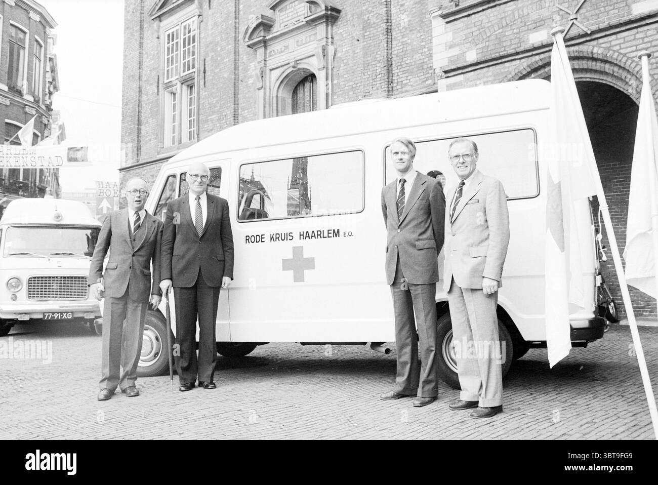 Quattro sindaci di fronte alla Croce Rossa auto Croce Rossa Croce Rossa ospedale, Whizgle News, Dutch Desk, Paesi Bassi, 1950 - 2000 il 22-05-1981. Questi sono gli elementi dell'immagine. Nella scena, quattro uomini stanno in primo piano, formando un gruppo accanto a un furgone bianco con il simbolo di una croce rossa. Il furgone sembra essere un veicolo di servizio, molto probabilmente associato a servizi di emergenza o sanitari. Gli uomini sono vestiti con un abbigliamento formale; tre di loro indossano abiti mentre uno ha un blazer più casual, suggerendo approcci diversi all'evento. Le loro espressioni trasmettono un mix di serietà e. Foto Stock
