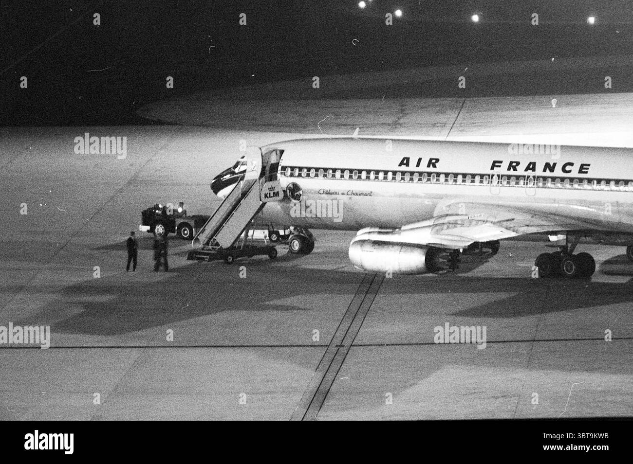 Ostaggi a Schiphol - partenza con Air France. Situazione degli ostaggi Schiphol, Whizgle News, Dutch Desk, Paesi Bassi, 1950 - 2000 il 17-09-1974. Questi sono gli argomenti nell'immagine. La scena cattura un vivace ambiente aeroportuale durante le ore serali. Un elegante aeroplano, con l'emblema di Air France, è parcheggiato su un asfalto illuminato da numerose luci, che proiettano una luce soffusa sull'intera area. La fusoliera dell'aereo è dipinta con una livrea classica caratterizzata da un'audace combinazione di bianco, con accenti scuri, che gli conferiscono un aspetto elegante ma vintage. In primo piano, due terra cr Foto Stock