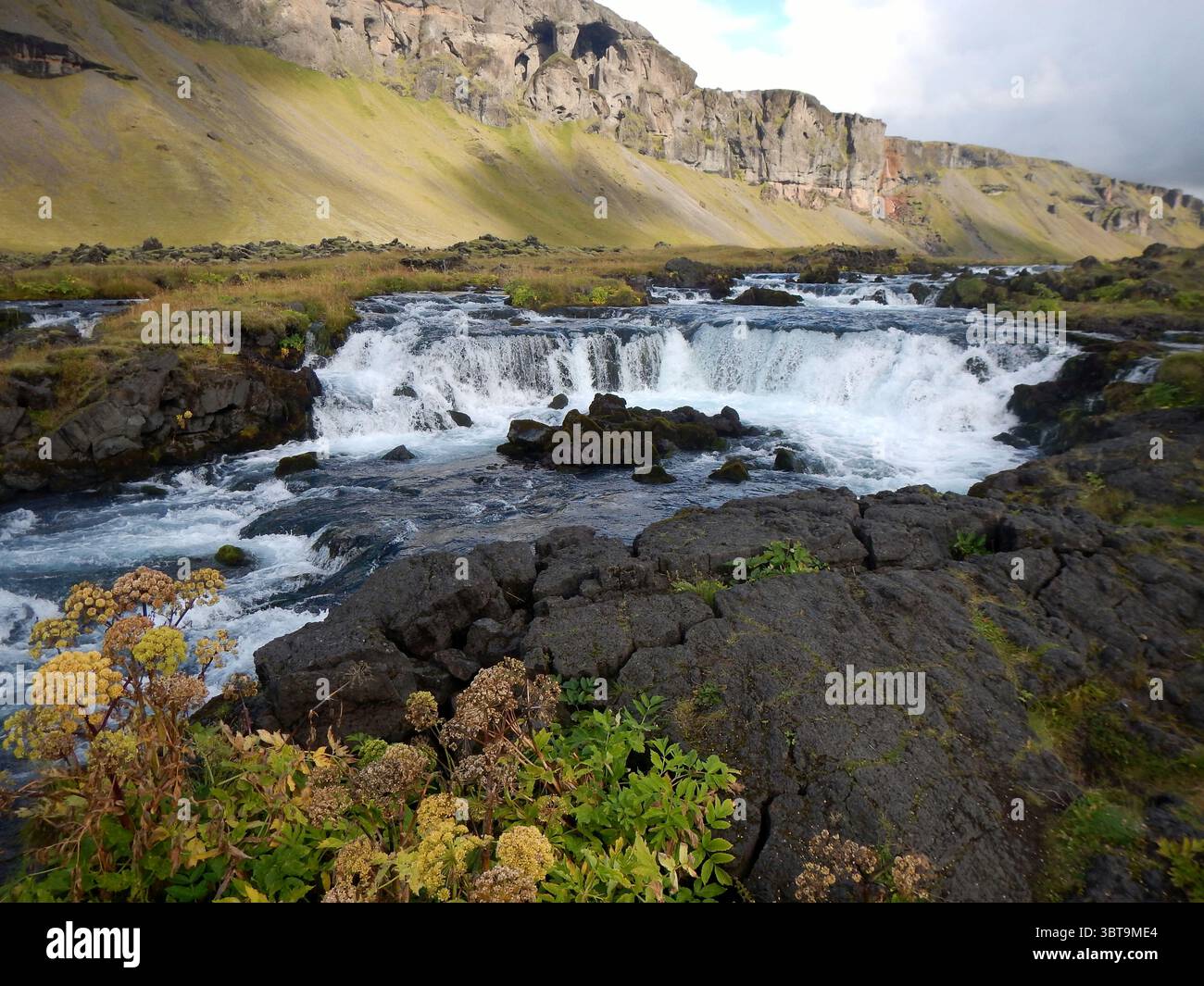 Piccola cascata sulle rocce vulcaniche nella remota valle islandese Foto Stock