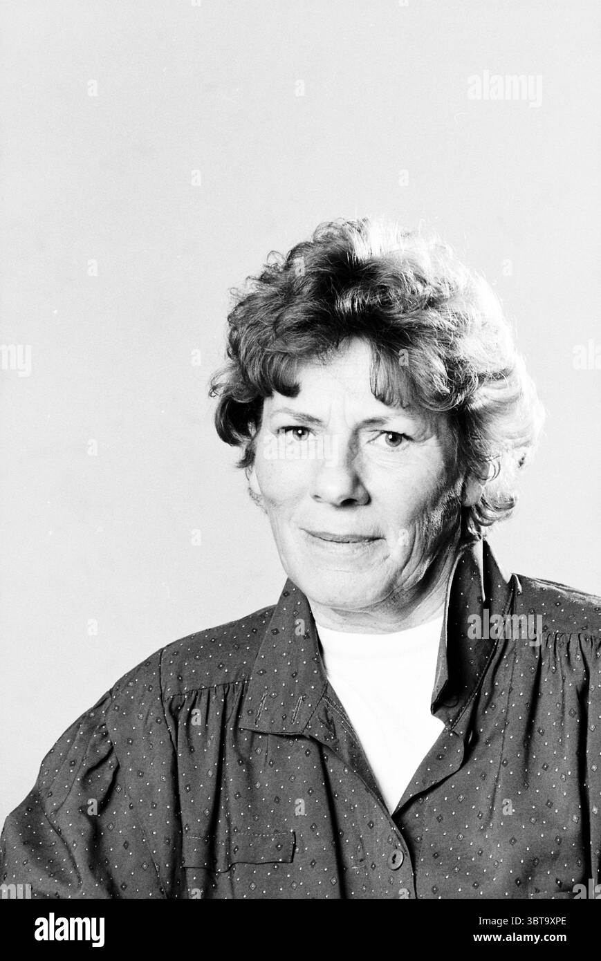 Foto del passaporto di F. de Boer, Whizgle News, Dutch Desk, Paesi Bassi, 1950 - 2000 il 07-02-1992. L'immagine contiene questi argomenti. La scena presenta una donna anziana con un'espressione premurosa, seduta su uno sfondo chiaro e neutro che aggiunge un'aria di semplicità alla composizione. I suoi capelli sono morbidi e ricci in una tonalità di marrone chiaro, incorniciando delicatamente il suo viso. Indossa una camicetta dalla vestibilità morbida, caratterizzata da sottili puntini polka, che introduce un tocco di fantasia senza travolgere la visuale. L'illuminazione è morbida e diffusa, creando un'atmosfera che esalta l'atmosfera Foto Stock