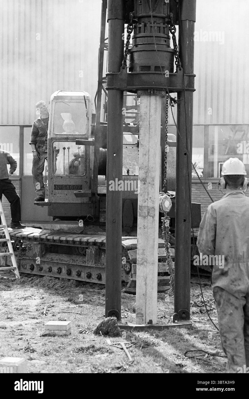 Simon Lévelt, costruzione e disegni di torrefazione e commercio del tè. Haarlem A. Hofmanweg Paesi Bassi, Whizgle News, Dutch Desk, Paesi Bassi, 1950 - 2000 il 23-04-1995. Questi sono gli argomenti nell'immagine. La scena ritrae un cantiere caratterizzato da un mix di macchinari industriali e attività umana. Al centro della scena c'è una macchina grande e imponente, probabilmente un mucchio. Si erge alto, con una struttura robusta e rinforzata che presenta un mix di metallo scuro e ruggine. L'operatore della macchina è visibile in una cabina trasparente, concentrandosi sull'attività da svolgere. Intorno alla m Foto Stock