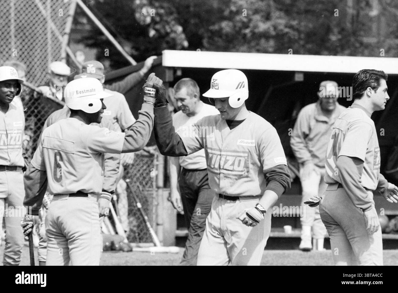 Baseball: Pioniers - Nicols Hoofddorp Paesi Bassi, Whizgle News, Dutch Desk, Paesi Bassi, 1950 - 2000 il 08-05-1991. Questi sono gli argomenti nell'immagine. La scena cattura un momento dinamico di una partita di baseball, sullo sfondo di un campo sportivo all'aperto. Si possono vedere diversi individui in uniforme da baseball, indossando prevalentemente magliette grigio chiaro adornate con un logo. Un mix di entusiasmo e determinazione è palpabile tra i giocatori. In primo piano, due atleti sono impegnati in un gesto celebrativo, che si susseguono con un'emozione visibile sui loro volti. I loro caschi Foto Stock