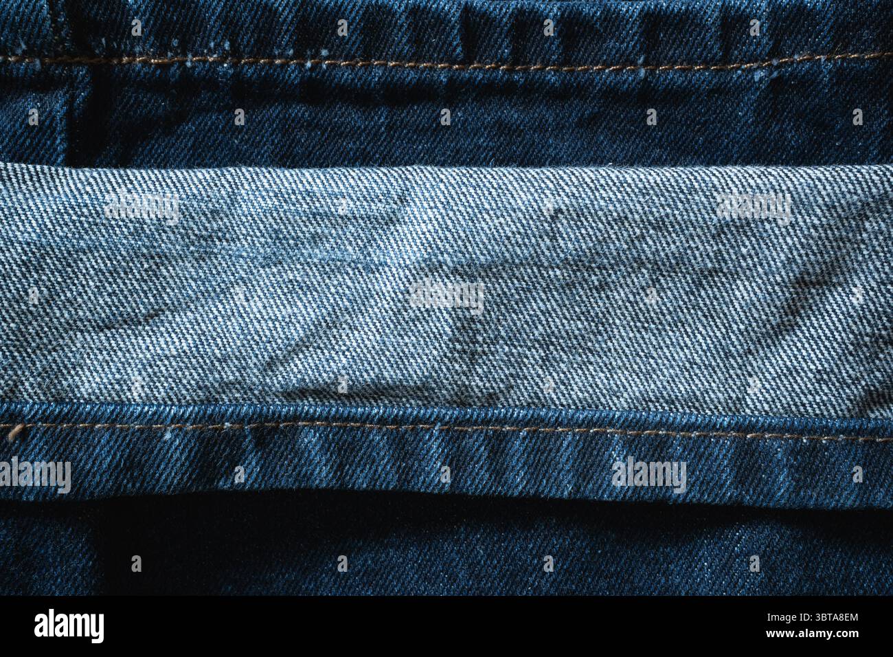 Lo spazio per le copie è creato dal polsino piegato dei jeans blu, dove un blu più chiaro incontra il denim più scuro Foto Stock
