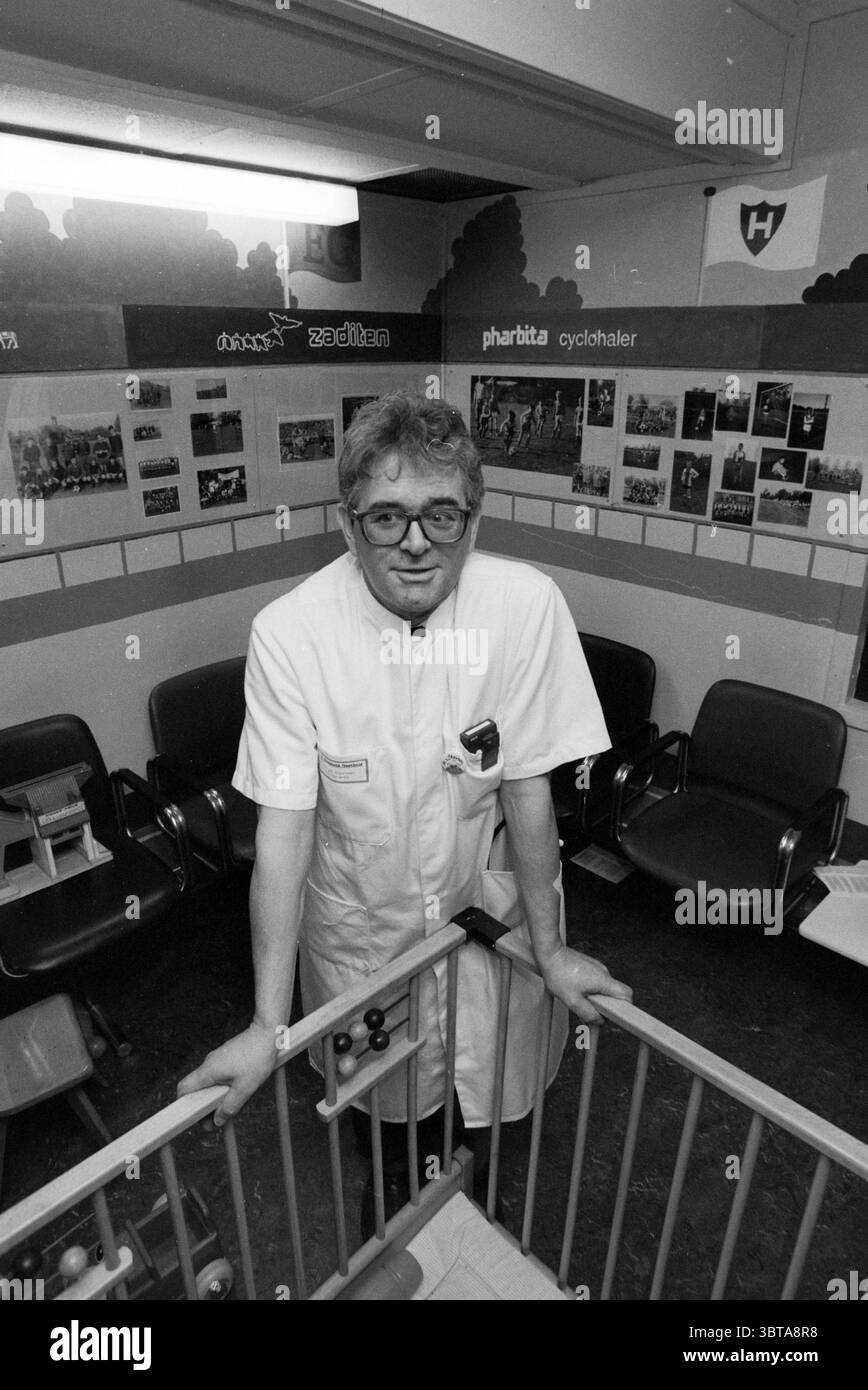 Cees van. Steijnen EG poli, Whizgle News, Dutch Desk, Paesi Bassi, 1950 - 2000 il 30-10-1991. L'immagine mostra questi argomenti. In una stanza caratterizzata da un'atmosfera clinica e professionale, una persona sta in piedi con le mani appoggiate sul bordo di un tavolo basso o di una ringhiera. Sono vestiti con un cappotto bianco, che suggerisce un ruolo nel campo medico o sanitario. L'individuo ha occhiali e un'espressione premurosa che trasmette un senso di autorità ed esperienza. L'ambiente e' decorato minimamente, con una varieta' di fotografie incorniciate e poster montati sulle pareti, che danno uno scorcio Foto Stock Cees van. Steijnen EG poli, Whizgle News, Dutch Desk, Paesi Bassi, 1950 - 2000 il 30-10-1991. L'immagine mostra questi argomenti. In una stanza caratterizzata da un'atmosfera clinica e professionale, una persona sta in piedi con le mani appoggiate sul bordo di un tavolo basso o di una ringhiera. Sono vestiti con un cappotto bianco, che suggerisce un ruolo nel campo medico o sanitario. L'individuo ha occhiali e un'espressione premurosa che trasmette un senso di autorità ed esperienza. L'ambiente e' decorato minimamente, con una varieta' di fotografie incorniciate e poster montati sulle pareti, che danno uno scorcio Foto Stock