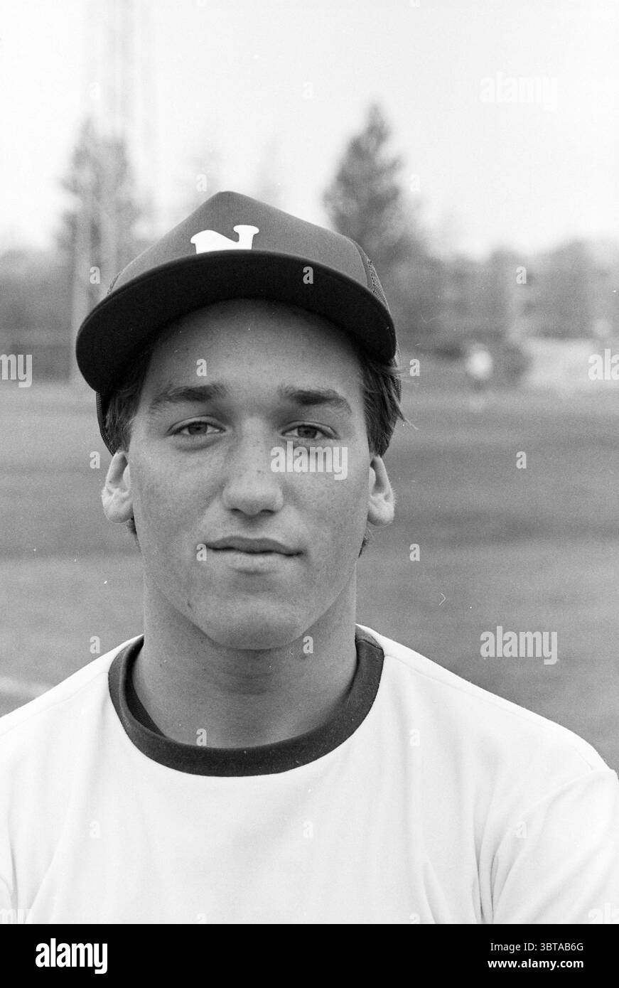 Portraits of Players Nicols Baseball Baseball Haarlem Nicols, Whizgle News, Dutch Desk, Paesi Bassi, 1950 - 2000 on 25-04-1981. Questi argomenti vengono visualizzati nell'immagine. La scena presenta un giovane atleta maschile catturato in un momento di calma concentrata. Ha i capelli corti e scuri, leggermente ruvidi e un'espressione rilassata che suggerisce sicurezza e un certo grado di introspezione. Indossa una maglia di colore chiaro che contrasta con le sfumature più profonde del suo berretto, che mostra in modo prominente una lettera, probabilmente indicativa di una squadra o di una scuola. Lo sfondo rivela un campo erboso, suggerendo un ambiente sportivo Foto Stock