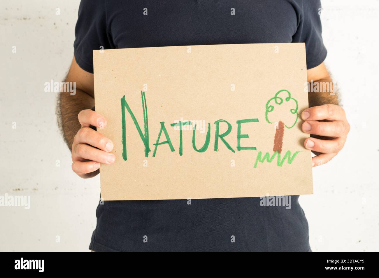 uomo che indossa una t-shirt blu navy con un cartello e un messaggio ambientale Foto Stock