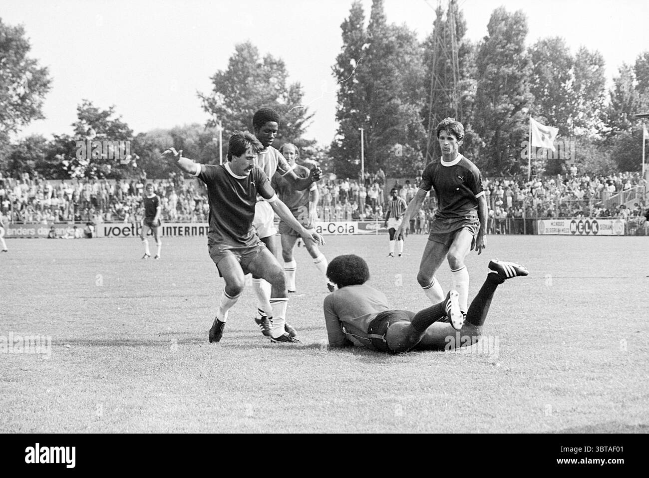 Haarlem - Robin Hood Football Haarlem, Whizgle News, Dutch Desk, Paesi Bassi, 1950 - 2000 il 15-08-1976. L'immagine include questi argomenti. In un ambiente sportivo vivace, un gruppo di quattro atleti viene catturato in un momento dinamico su un campo erboso, circondato da una folla entusiasta. I giocatori indossano maglie abbinate, prevalentemente nelle tonalità blu scuro e rosso, con pantaloncini variegati che si abbinano ai colori audaci dei loro top. Tra questi, un giocatore si trova trionfalmente con le braccia allungate, trasudando un'energia esuberante, mentre altri due si impegnano da vicino, probabilmente celebrando o stratega Foto Stock