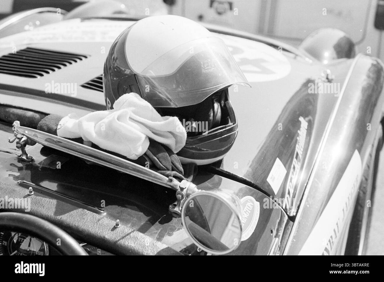 Il pilota Michael Bleekemolen, Whizgle News, Dutch Desk, Paesi Bassi, 1950 - 2000 il 19-08-1995. L'immagine mostra questi argomenti. La scena cattura un'auto da corsa d'epoca, caratterizzata da un design elegante e aerodinamico e da un'audace tavolozza di colori che probabilmente include rossi o blu, esaltandone l'estetica sportiva. La superficie dell'auto risplende sotto la luce del sole, riflettendo l'ambiente circostante e contribuendo a creare un senso di vivacità e velocità. Accanto all'auto, un casco poggia in modo prominente sulla carrozzeria, indicando il suo legame con gli sport motoristici. La visiera del casco è parzialmente colorata, Foto Stock