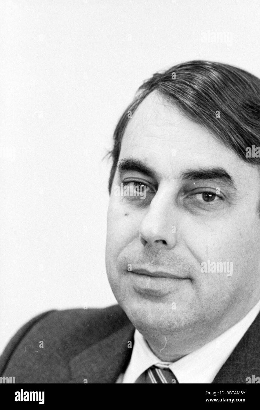 Ritratti del presidente della camera di commercio e direttore della NZH Mr. Testa Chamber of Commerce and Facilities Noord Zuid Hollandse Vervoersmaatschappij N.V. NZ, Whizgle News, Dutch Desk, Paesi Bassi, 1950 - 2000 il 04-04-1989. L'immagine include questi argomenti. La scena presenta un uomo con capelli scuri e corti e una leggera onda, su uno sfondo semplice e chiaro che crea un senso di semplicità e concentrazione. La sua espressione è neutrale, trasuda un comportamento calmo, con gli occhi leggermente decentrati, aggiungendo un'aria di contemplazione. E' vestito con un vestito scuro, a dimostrazione di una p Foto Stock