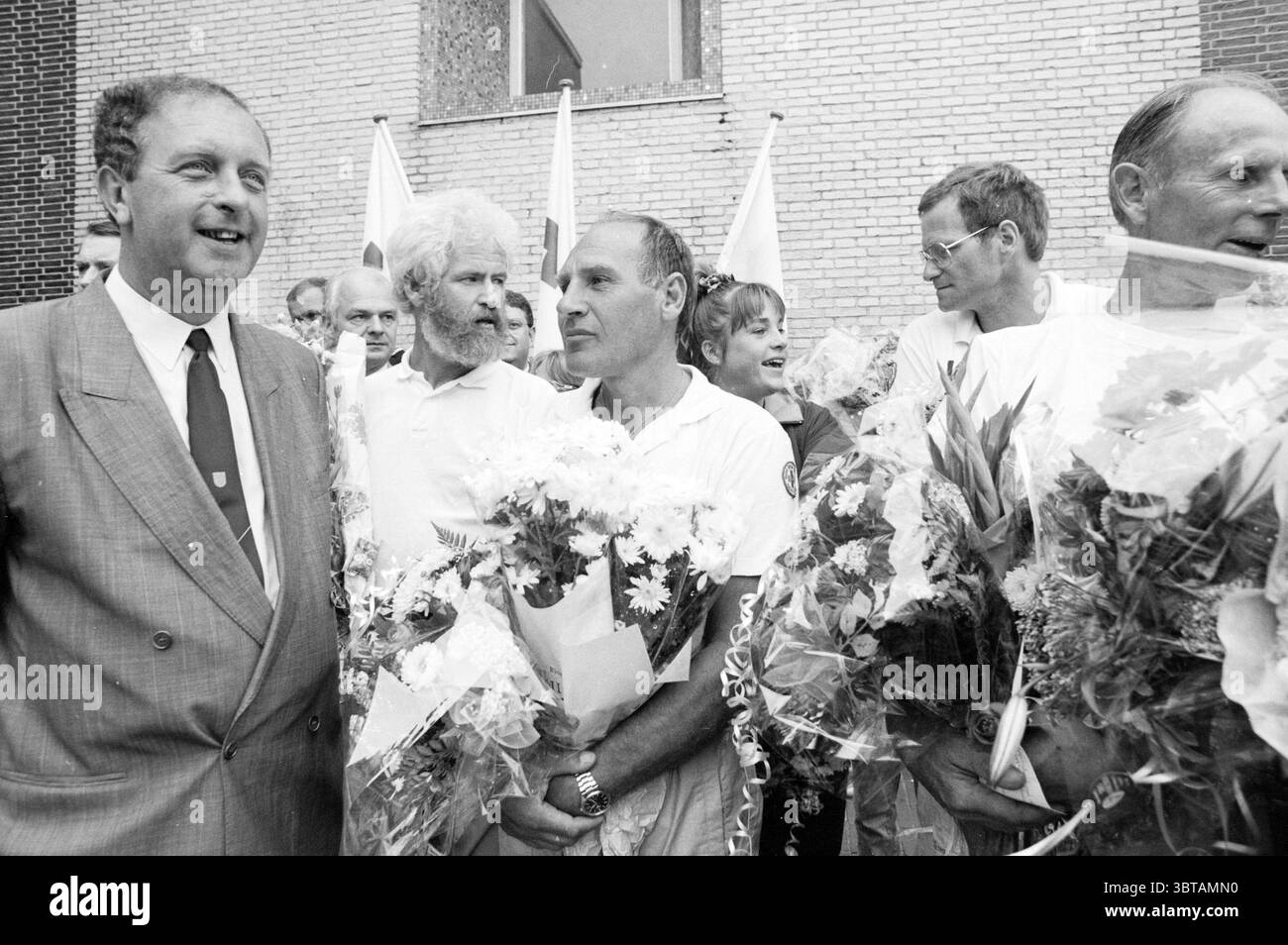 Tour a piedi della Croce Rossa arrivo a piedi, Whizgle News, Banco olandese, Paesi Bassi, 1950 - 2000 il 10-09-1988. Questi sono gli argomenti nell'immagine. La scena cattura un gruppo di persone riunite all'aperto, trasudando un senso di celebrazione o di successo. L'atmosfera e' piena di un'atmosfera vivace, mentre i partecipanti sfoggiano un sorriso luminoso e mostrano un'aria di cameratismo. In primo piano, diversi uomini stanno vicini tra loro, ognuno dei quali racchiude un assortimento di fiori, prevalentemente in colori pastello come il bianco e il rosa tenue, che aggiungono un tocco di calore alla scena. I fiori sono lussureggianti, a indicare Foto Stock