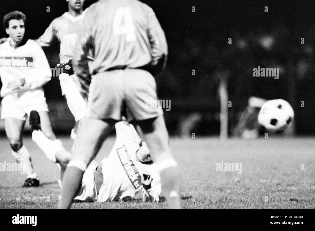 Telstar - Ajax Football Telstar, Whizgle News, Dutch Desk, Paesi Bassi, 1950 - 2000 il 14-01-1986. Questi argomenti sono mostrati nell'immagine. La scena cattura un momento dinamico su un campo da calcio, illuminato da un'illuminazione artificiale che crea un contrasto spettacolare con l'ambiente oscuro. In primo piano sono presenti due giocatori, uno a terra che si aggrappano all'erba e l'altro in un'azione pronta a colpire. Le loro uniformi mostrano colori vibranti e contrastanti, con una tonalità più chiara e l'altra in tonalità più profonde, enfatizzando il loro ruolo nel gioco. Sullo sfondo, un terzo Foto Stock