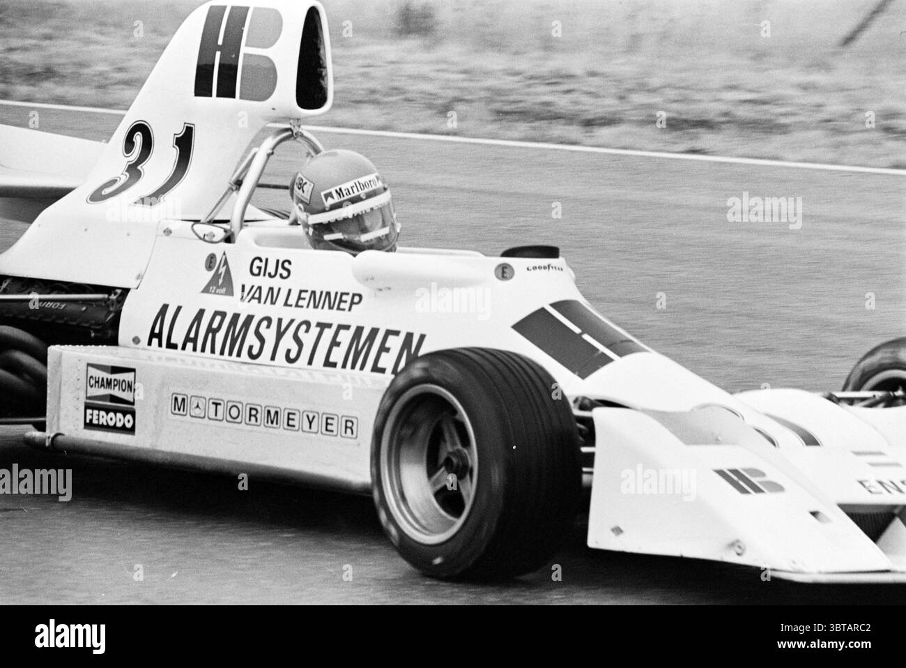 Grand Prix a Zandvoort Grand Prix, Whizgle News, Dutch Desk, Paesi Bassi, 1950 - 2000 il 22-06-1975. Questi sono gli elementi dell'immagine. La scena cattura un evento di corse ad alta velocità con una classica auto da corsa a ruota aperta in movimento. Il veicolo, prevalentemente bianco con audaci accenti neri e rossi, presenta un design elegante e aerodinamico tipico della sua epoca. L'ampia aletta posteriore e il profilo ribassato ne evidenziano la progettazione, suggerendo velocità e agilità. All'interno dell'abitacolo, un pilota è concentrato e rivestito con un casco che protegge il viso, combinando sicurezza e un richiamo allo spirito audace dello sport. T Foto Stock