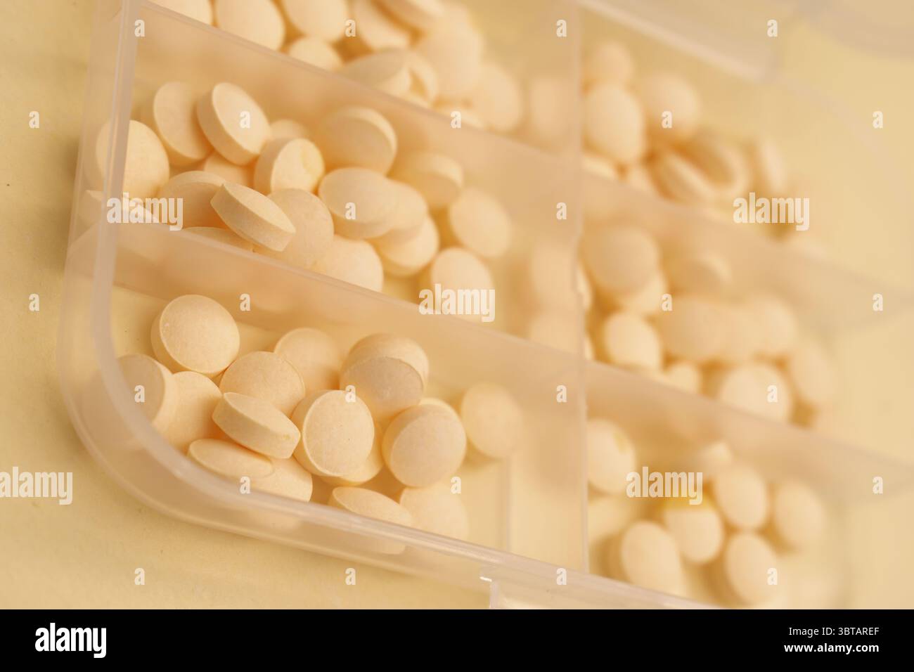 Concetto minimalista con pillole rotonde bianche in contenitore di vetro e cucchiaio su sfondo beige Foto Stock