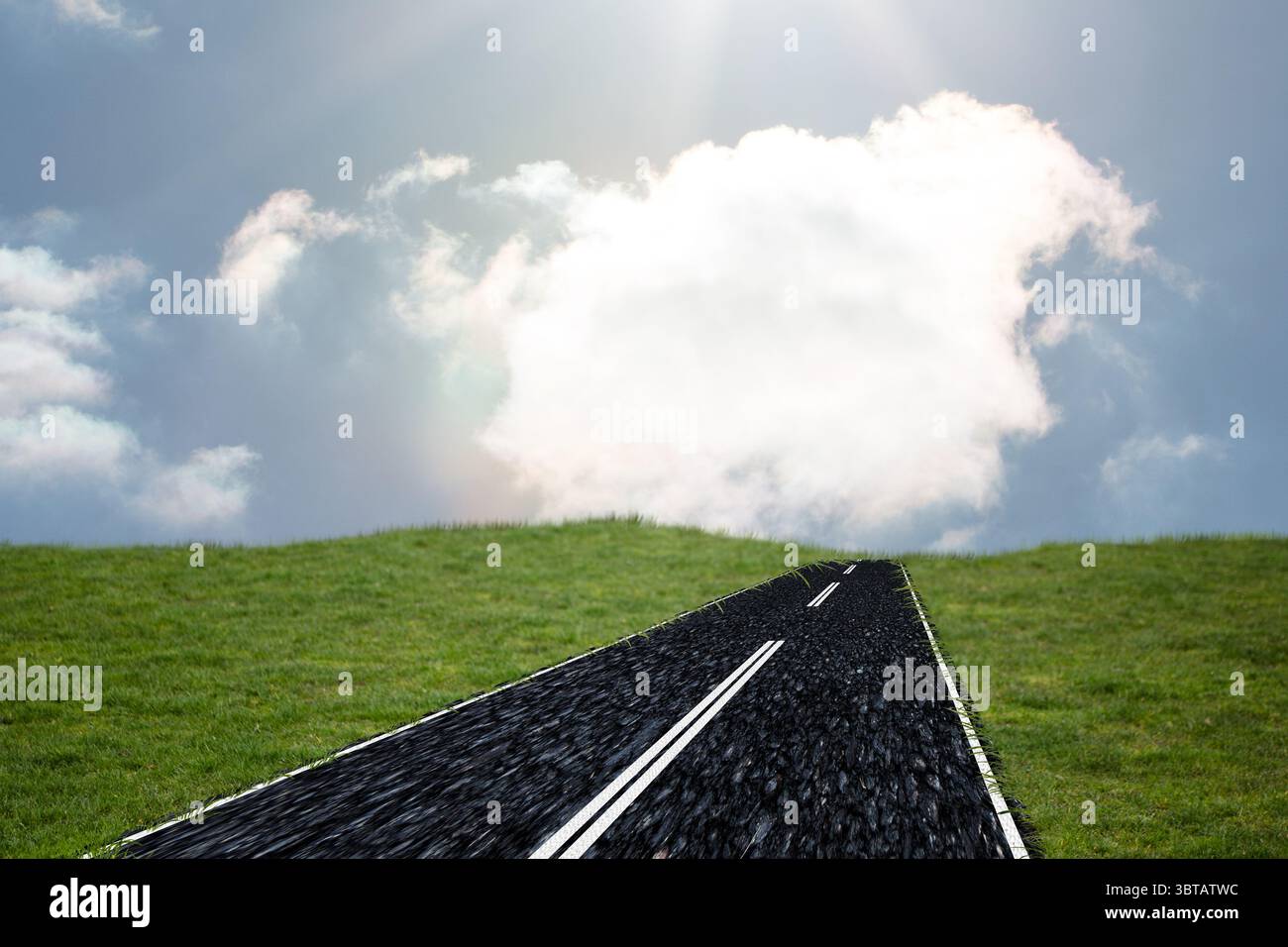 La strada asfaltata si sta arrampicando su una collina di erba verde in piano, mostrando linee tratteggiate e nuvole Foto Stock