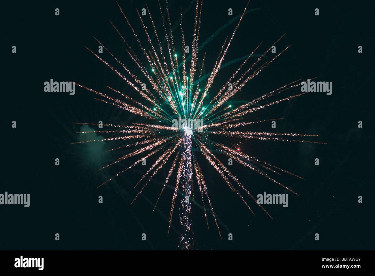 Un grande fuochi d'artificio illumina il cielo notturno, riempendolo di colori brillanti e di un bagliore festoso. Foto Stock