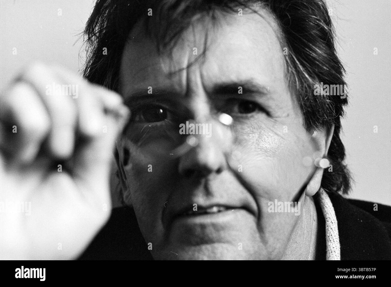 Jean de Ruijter SBK, Whizgle News, Dutch Desk, Paesi Bassi, 1950 - 2000 il 10-04-1995. L'immagine mostra questi argomenti. Il punto focale è un individuo di mezza età con capelli scuri e duri, che mostra un'espressione contemplativa. La pelle ha un aspetto naturale e leggermente ruvido, che suggerisce calore e carattere. Una mano tiene un paio di occhiali vicino al viso e le lenti riflettono la luce circostante, creando un leggero riflesso che cattura l'attenzione. Lo sfondo è leggermente sfocato, contribuendo a una profondità focalizzata intorno al soggetto. L'illuminazione generale è morbida e diffusa, addin Foto Stock