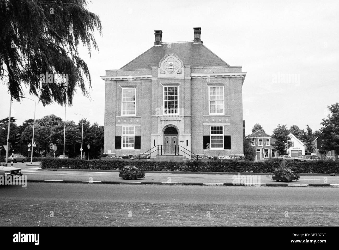 Esterno del Polderhuis sul Marktplein a Hoofddorp. Dal 1979 il centro amministrativo del bacino idrico di Groot-Haarlemmermeer si trova qui. Hoofddorp Marktplein Paesi Bassi, Whizgle News, Dutch Desk, Paesi Bassi, 1950 - 2000 il 06-08-1980. Questi sono gli elementi dell'immagine. La scena presenta un grande e maestoso edificio con un'imponente facciata in mattoni. La struttura è caratterizzata da un design simmetrico, evidenziato da alte e strette finestre che fiancheggiano un ingresso centrale. L'entrata presenta una serie di scalini che portano a doppie porte, che sono ornamentali dettagliate. L'uppe Foto Stock