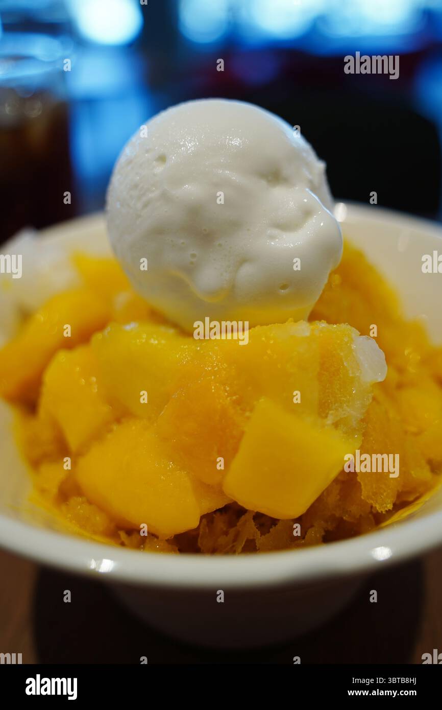 Gelato al mango con condimento al mango fresco nel White Bowl Foto Stock