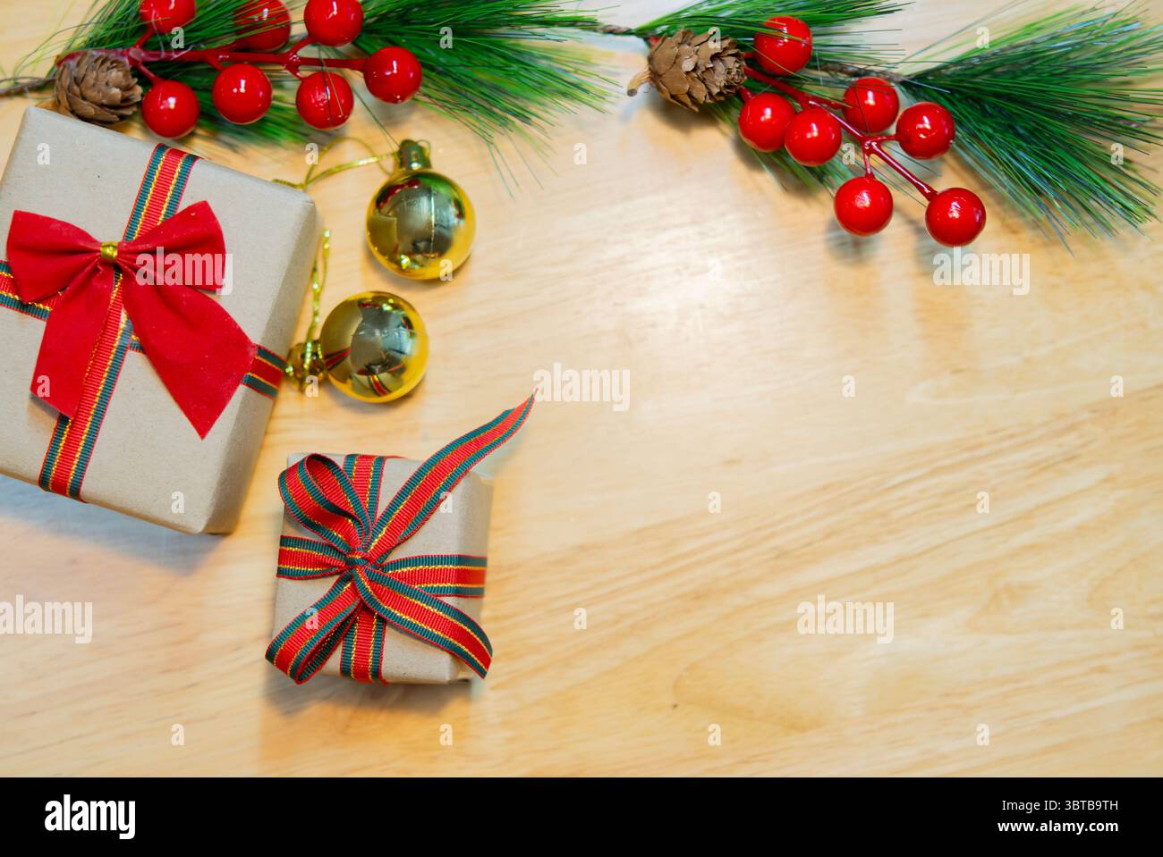 Scatole regalo di Natale marroni con rami di abete e decorazioni su un tavolo in legno. Copia spazio. Foto Stock