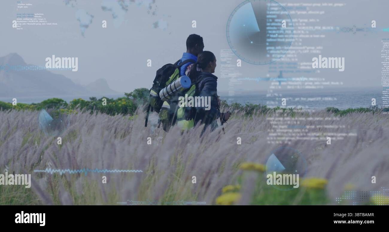 Escursionisti che indossano attrezzatura e zaini che sorvegliano la prateria costiera di fiori selvatici, con sovrapposizioni radar codificate Foto Stock
