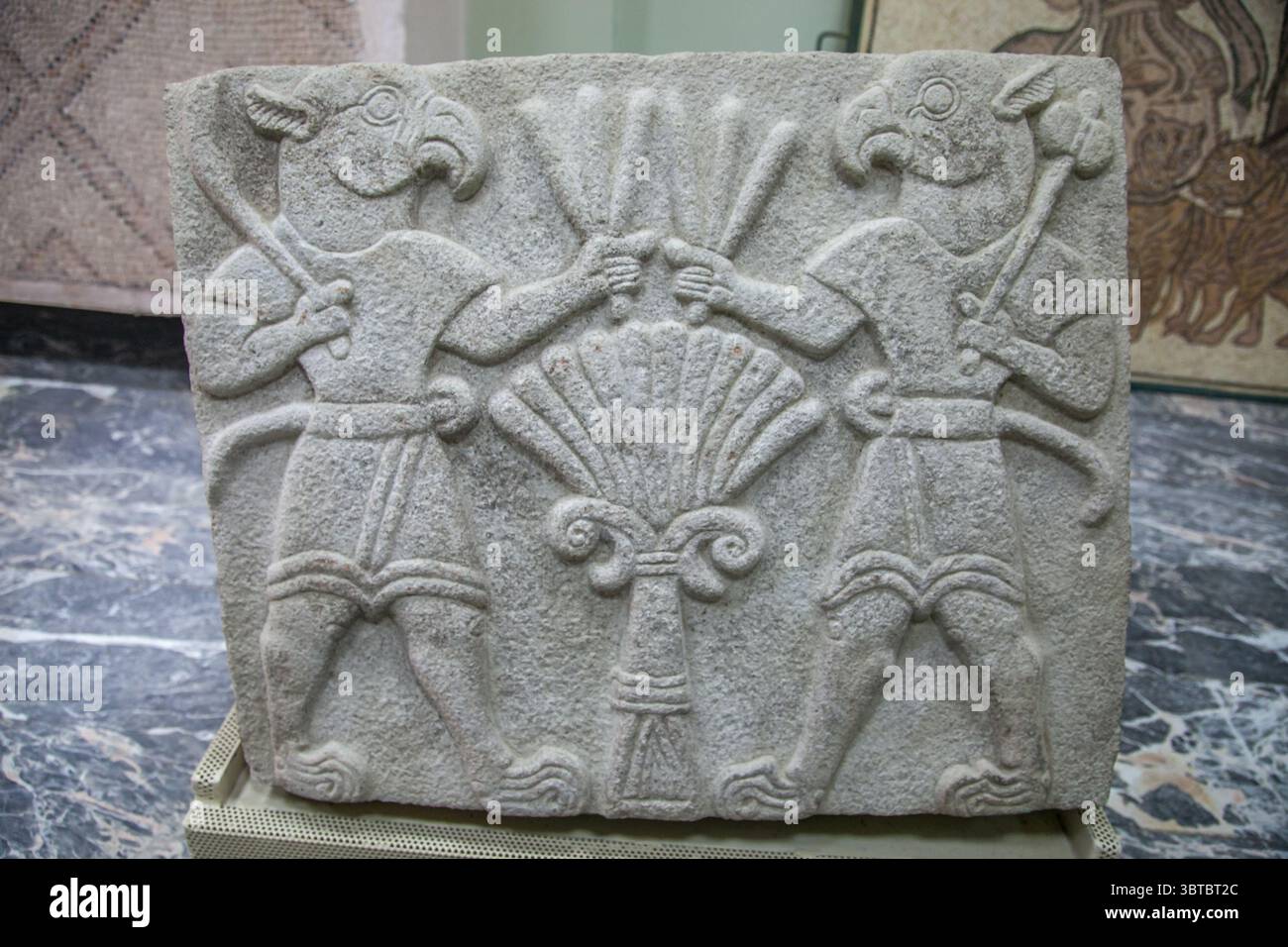 Rilievo raffigurante due figure con corpi umani e teste di uccello, uno di fronte all'altro con un simbolo di pianta stilizzato tra loro, Arslantepe, Turchia Foto Stock