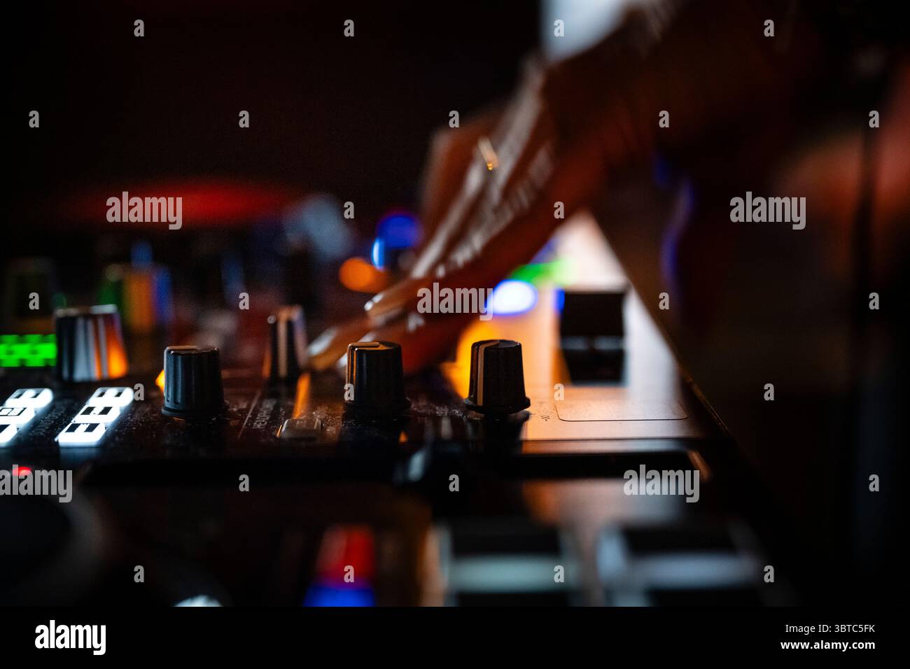 Primo piano di un DJ che mescola la musica con le dita e le mani. le dita toccano manopole, manopole e interruttori e riproduce e mixa musica. Foto Stock