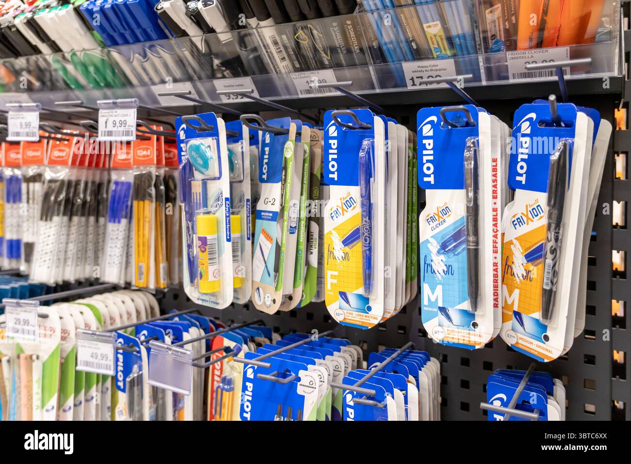 Poznan, Polonia - 30 giugno 2025: Primo piano di vivaci prodotti di cartoleria confezionati, tra cui penne in gel cancellabili e altri elementi essenziali per la scuola, in mostra o Foto Stock