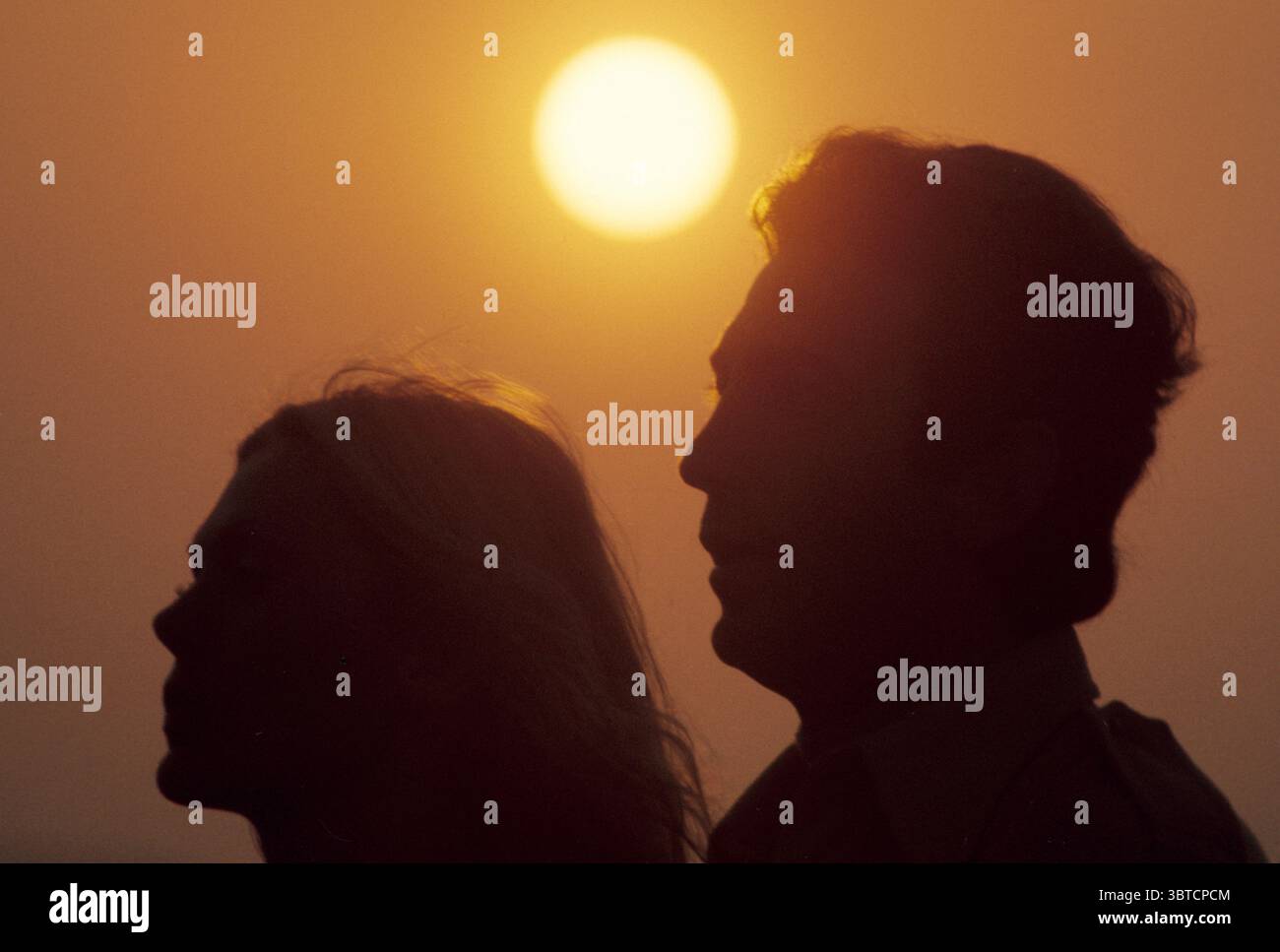 coppia ritratto profilo tramonto con grande sole sopra la testa cielo rosso estate relazione d'amore Foto Stock