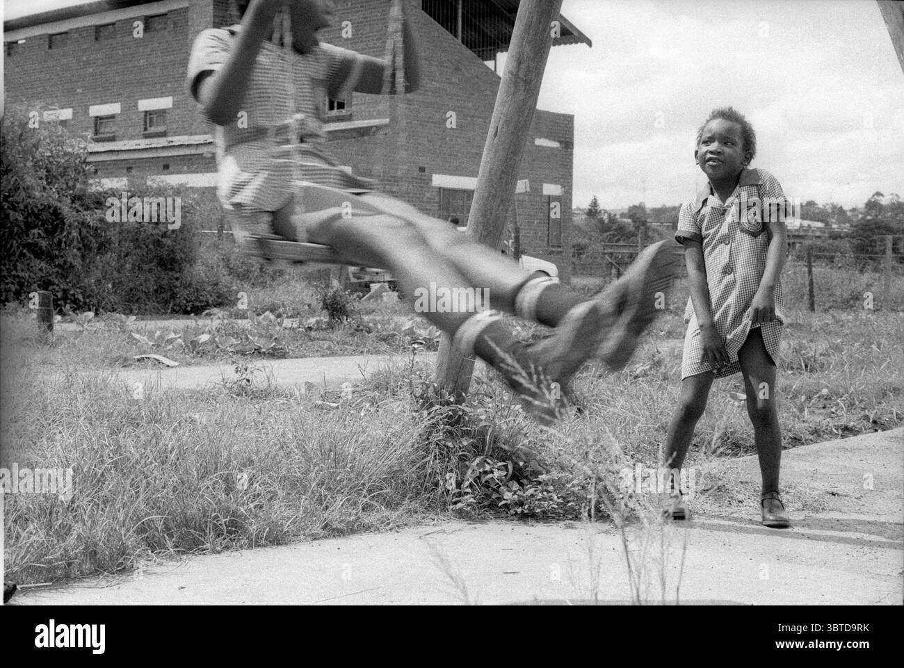 1 gennaio 2014, Pietermaritzburg, KwaZulu Natal, Sudafrica: Due ragazze giocano sulle altalene dopo la scuola...Jika Joe è un insediamento informale che si trova a cavallo di entrambe le sponde del fiume Dorpspruit nel centro di Pietermaritzburg, la capitale della provincia del KwaZulu Natal in Sudafrica. La sua massa è fatta di fango, frammenti di legno e cartone, i tetti di Jika Joe sono in lamiera, pezzi di pannelli rigidi e teloni venduti spazzati via dai camion di passaggio su una vicina autostrada. ..la vista di queste case autocostruite su tratti aperti di terra sudafricana non scomparirà presto. (Immagine di credito: © Foto Stock