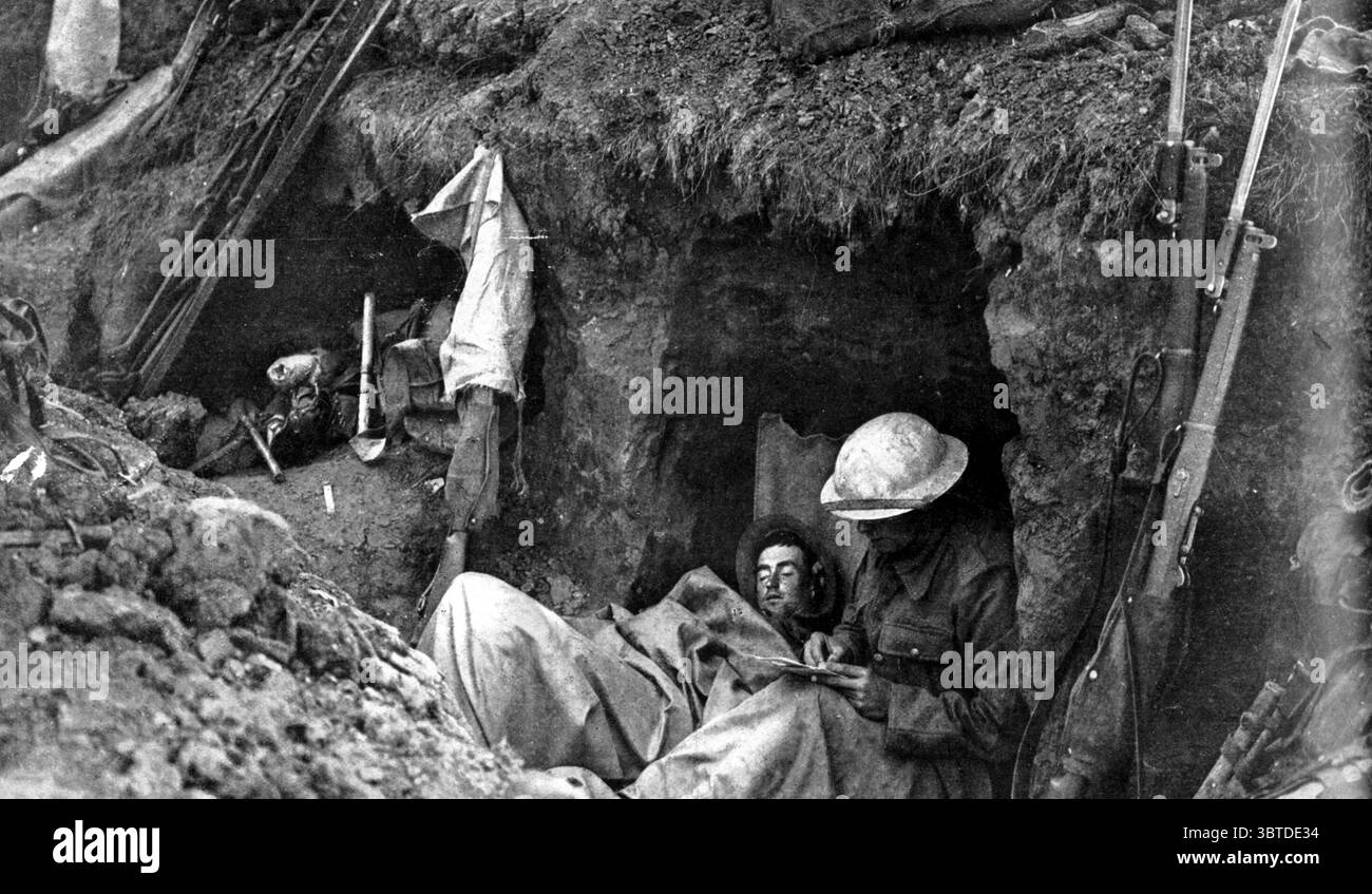Soldati britannici che si avvalgono di qualche minuto di pausa - scrivere a casa e dormire durante una pausa nel combattimento . questa vista è stata ripresa nelle trincee in prima linea quasi in vista del nemico : i due soldati hanno rilassato i loro sforzi per qualche minuto per riposare . Tutto è pronto , tuttavia , se una pattuglia nemica dovesse essere segnalata . La trincea è malamente constuccata, con la terra appena scavata davanti - è stata catturata durante l'avanzata e fatta affrontare intorno ai tedeschi formando un paradosso. I kit-bag dei due soldati sono nel rifugio sulla sinistra , vicino al quale sono anche ot Foto Stock