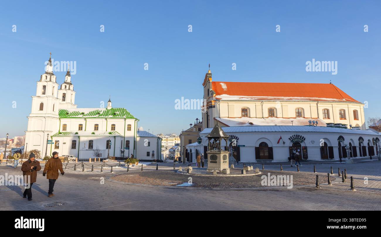 Minsk, Bielorussia - 7 gennaio 2024: Piazza della libertà in un giorno d'inverno soleggiato, la gente comune cammina per la strada di fronte alla sala concerti della città alta e Foto Stock