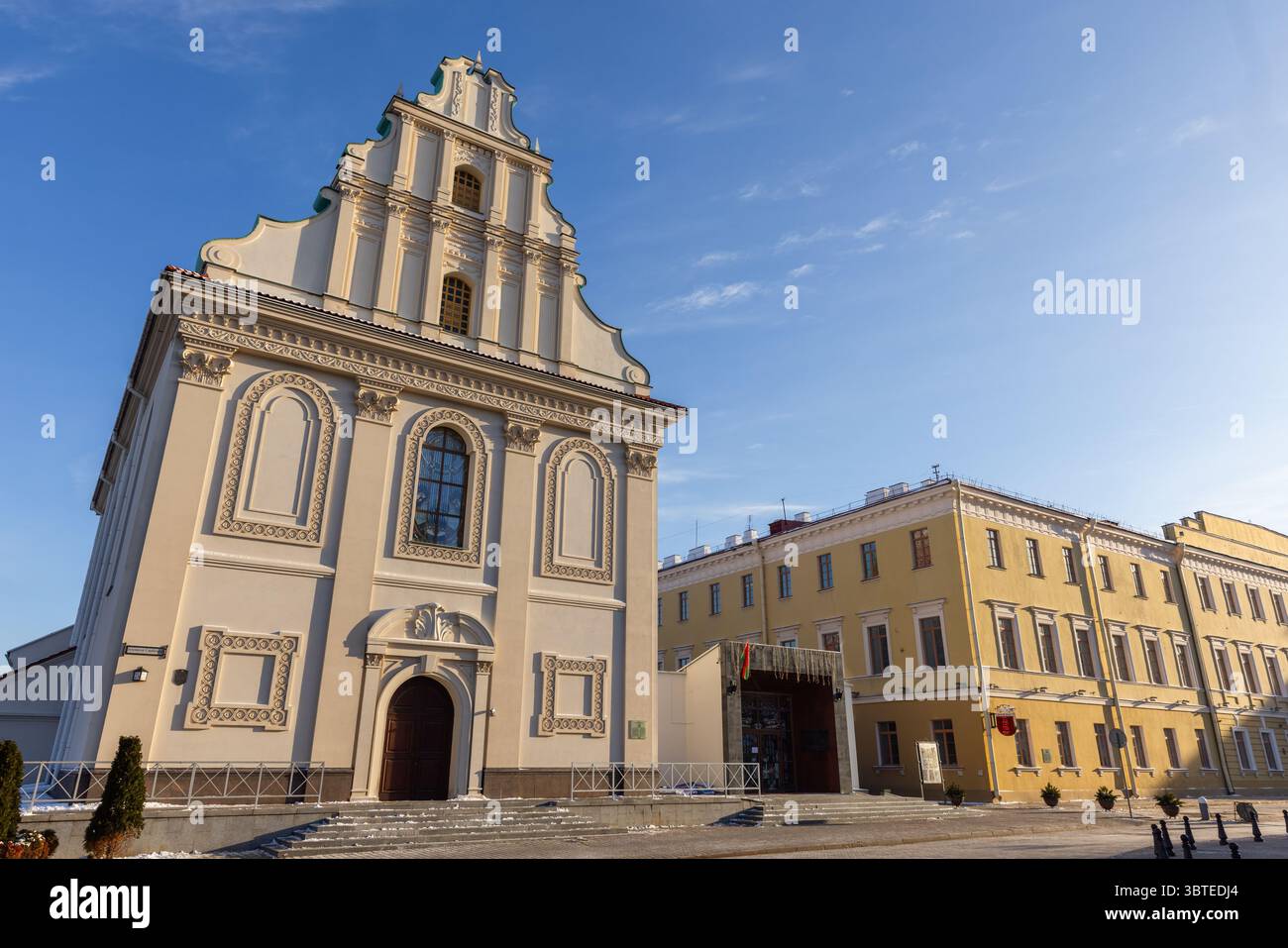 Minsk, Bielorussia - 7 gennaio 2024: Vista sulla strada con Piazza della libertà in un giorno d'inverno soleggiato, la facciata della sala concerti della città alta è in primo piano Foto Stock