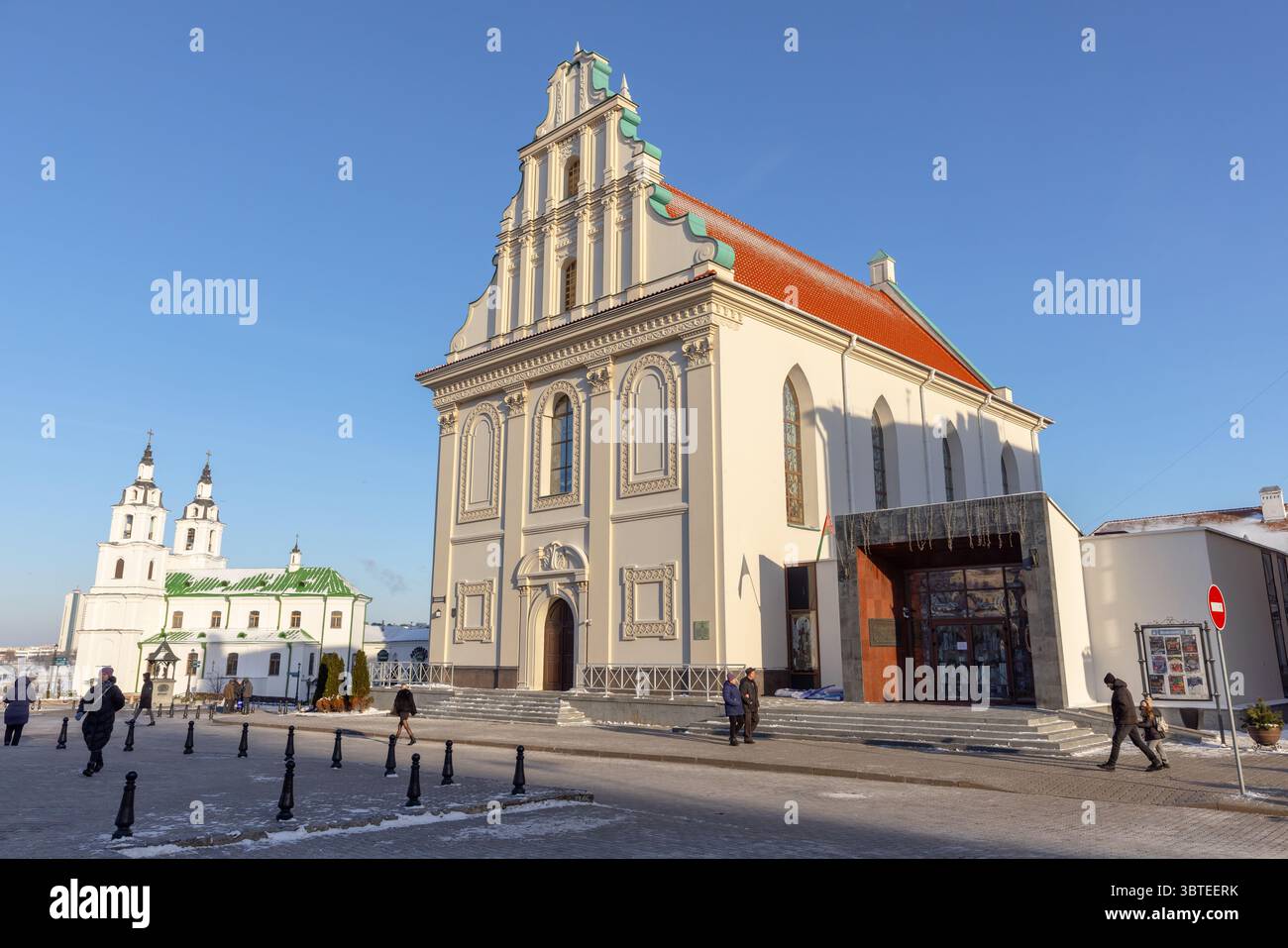 Minsk, Bielorussia - 7 gennaio 2024: Vista sulla strada con Piazza della libertà in una giornata invernale di sole, la gente comune cammina per la strada di fronte alla città alta Co Foto Stock