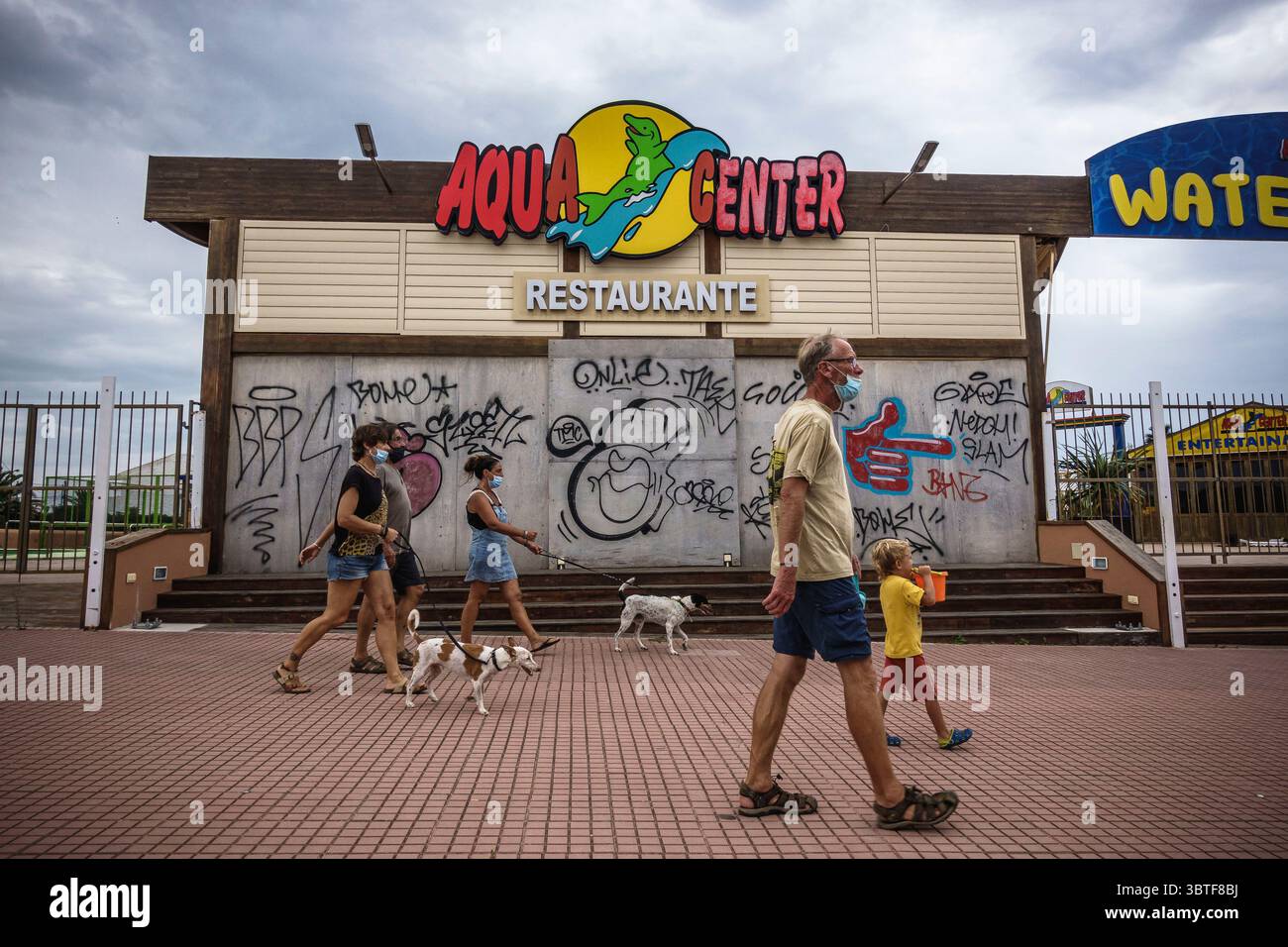 18 settembre 2020, Ciutadella, Isole Baleari, Spagna: I turisti camminano oltre il parco acquatico chiuso nella deserta località turistica "Los Delfines", un punto caldo normalmente vivace per la maggior parte dei turisti britannici di Minorca. Le Baleari hanno subito la crisi Covid-19 a causa degli avvertimenti di viaggio provenienti da diversi paesi e numerose aziende turistiche sono state costrette a chiudere le porte. (Immagine di credito: © Matthias Oesterle/ZUMA Wire) Foto Stock