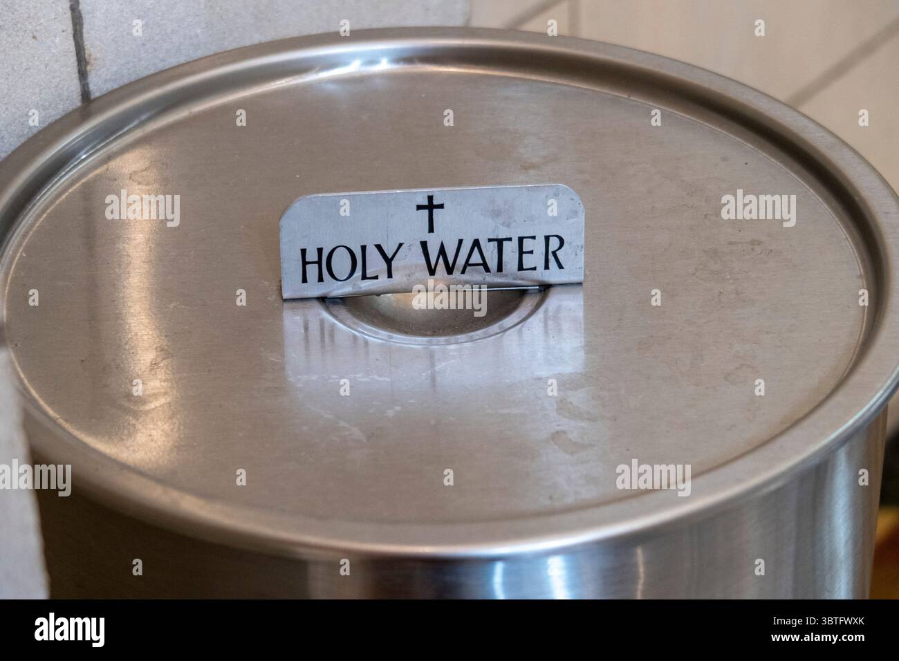 Acqua Santa nei contenitori dell'abbazia di Buckfast, Buckfastleigh, Devon, sede di una comunità di monaci benedettini, un ordine monastico del cattolico romano Foto Stock
