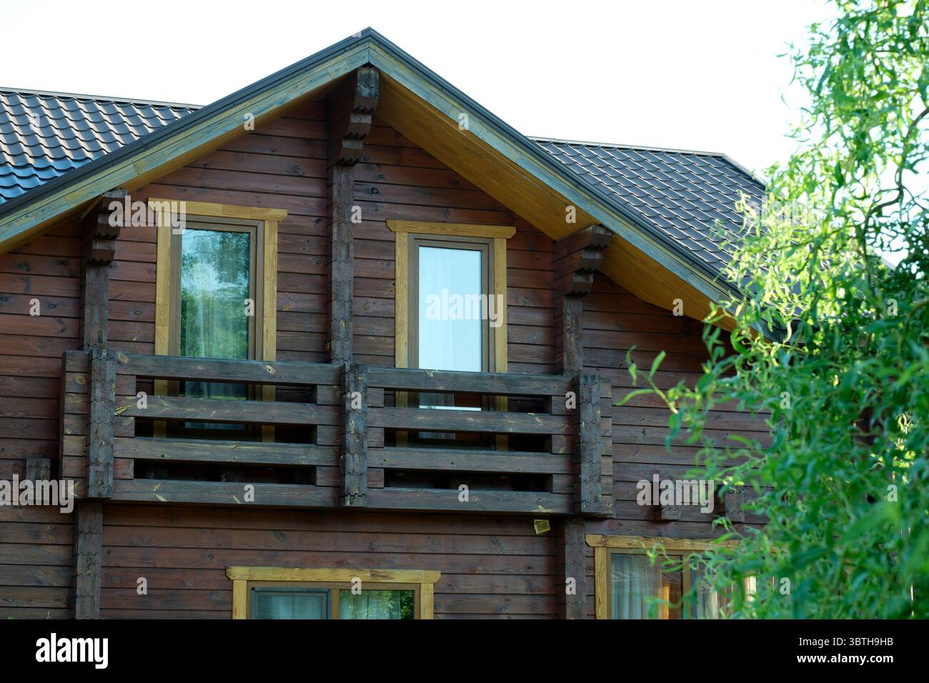 Un primo piano di una cabina di legno con balcone, finestre e tetto. Foto Stock
