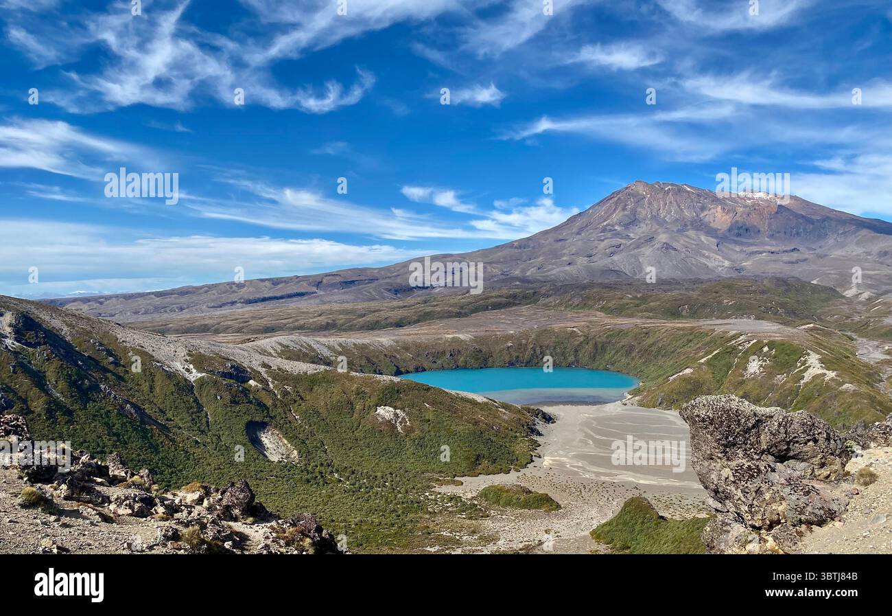Vivace lago turchese sul Tama Lake Trail, circondato da aspri terreni vulcanici e da una maestosa montagna in nuova Zelanda Foto Stock