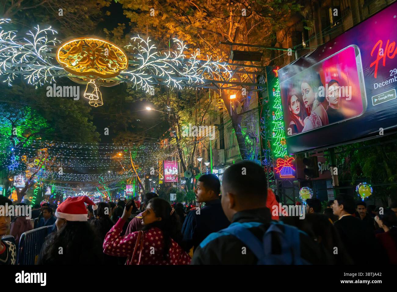 Kolkata, Bengala Occidentale, India - 25.12.2018 : giovani che si divertono in una strada illuminata e decorata con atmosfera festiva di fine anno. Foto Stock