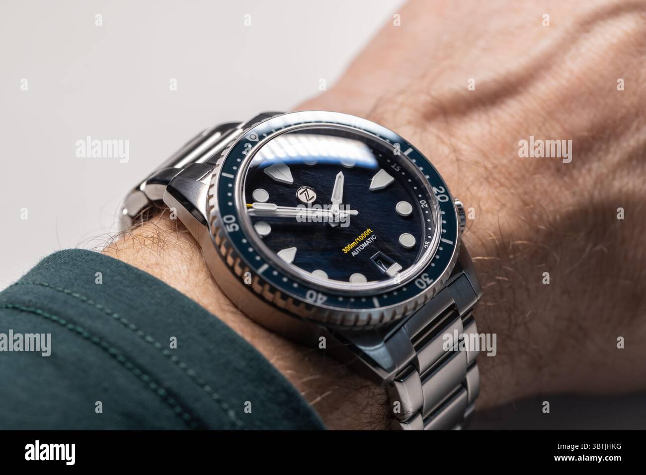 Singapore - 17 aprile 2025: Zelos Mako V3 300m Diver Falcons Eye, orologio subacqueo impermeabile sul polso maschile, foto macro con messa a fuoco morbida selettiva Foto Stock